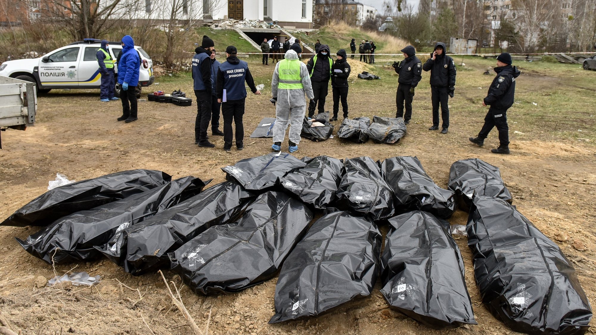epa09887828 Bodies are exhumed and removed from the mass grave near the St. Andrew and All Saints Church in Bucha city of Kyiv (Kiev) area, Ukraine, 13 April 2022. Forensic investigators began exhuming a mass grave in Bucha containing more than 410 bodies of civilians, according to Ukrainian officials. The UN Human Rights Council has decided to launch an investigation into the violations committed after Russia&#039;s full-scale invasion of Ukraine, the Ukrainian Parliament reported. Russian troops entered Ukraine on 24 February resulting in fighting and destruction in the country and triggering a series of severe economic sanctions on Russia by Western countries.  EPA/OLEG PETRASYUK