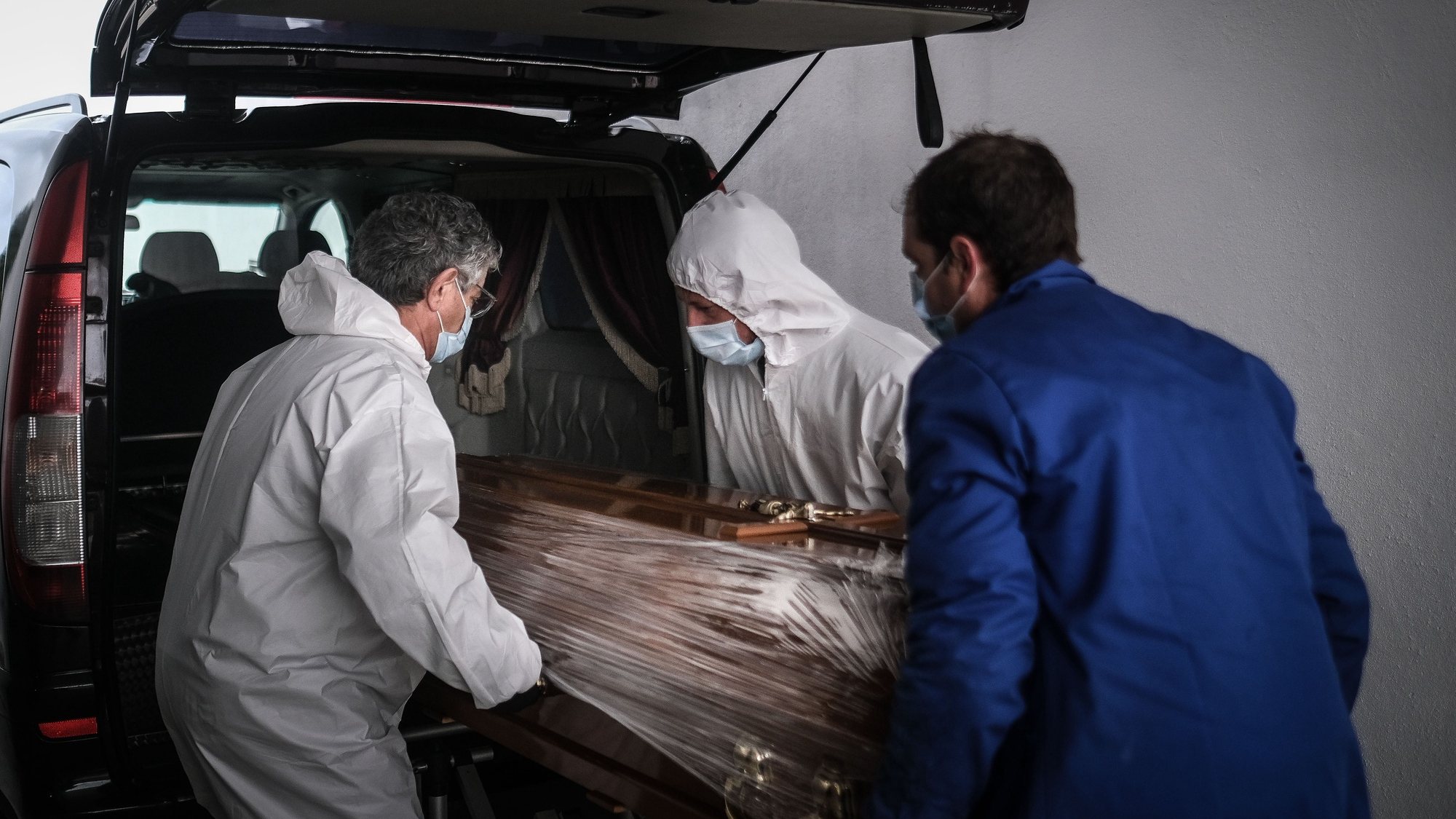 (13/23) Funcionários de uma agência funerária seguram o caixão de uma mulher que morreu vítima de covid-19, no Complexo Funerário Casal de Cambra, Sintra, 30 de janeiro de 2021. Esta semana Portugal ultrapassou as 300 mortes diárias por covid-19, um novo máximo desde o início da pandemia. (ACOMPANHA TEXTO DA LUSA DO DIA 30 DE JANEIRO DE 2021). MÁRIO CRUZ/LUSA