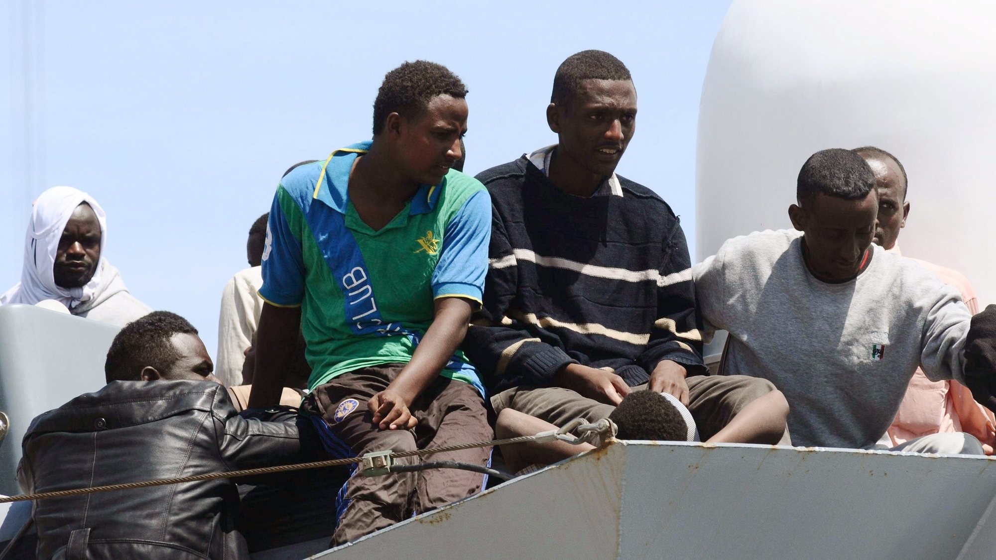 Migrantes aguardam para desembarcar de um navio italiano no porto de Sicília, Itália. 7 de junho de 2014