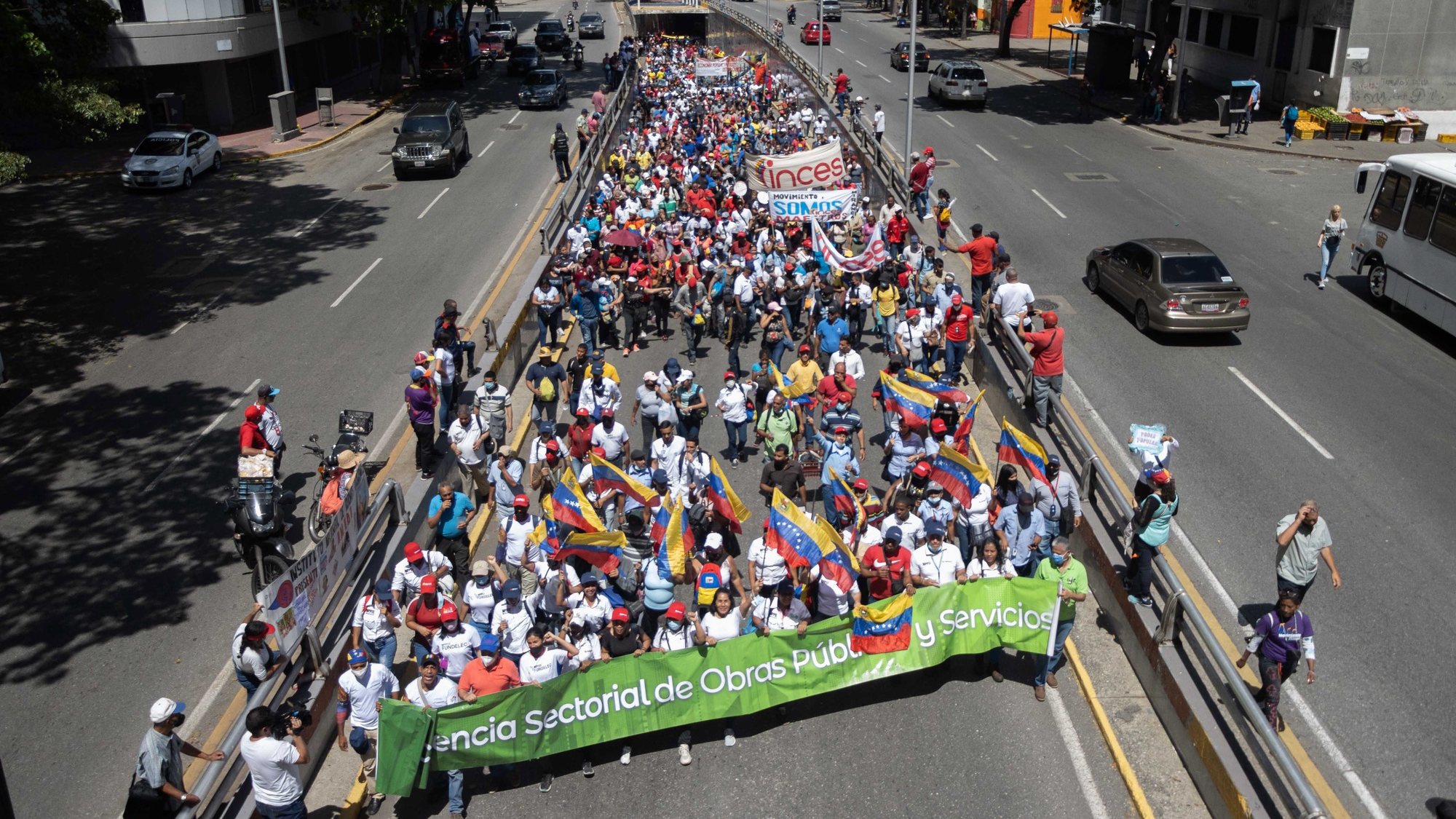 epa09921629 Workers of the public administration take part in a Chavista march for Workers Day, in Caracas, Venezuela, 01 May 2022. The President of Venezuela, Nicolas Maduro, approved on International Labor Day, a &#039;single bonus&#039; of 10,000 bolivares, about $2,227 dollars at the official exchange rate, for those workers who retired between 01 January 2018 and 01 May 2022.  EPA/Ronald Pena