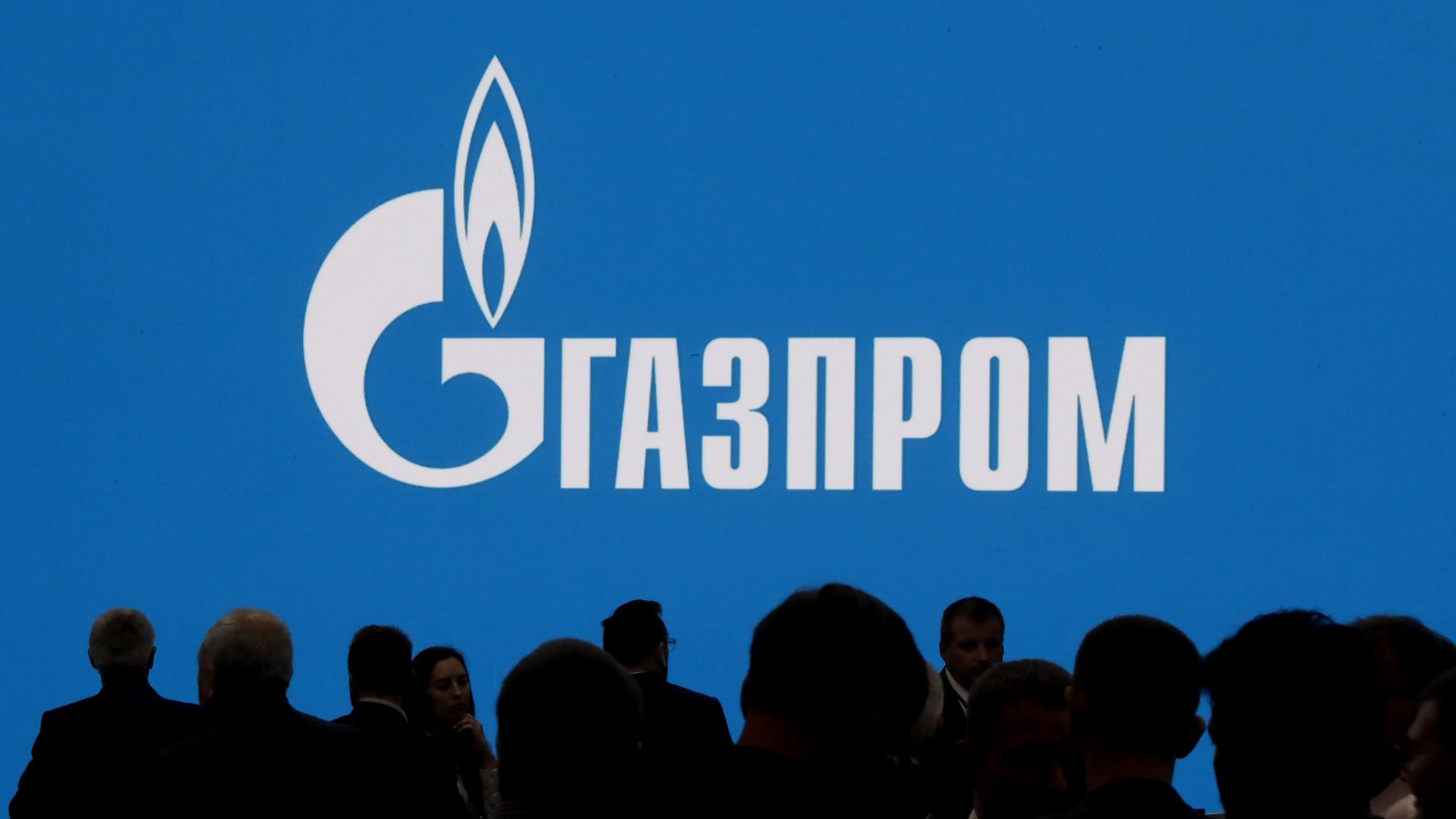 epaselect epa10181738 People walk in front of a large screen shows Gazprom Company logo at the St. Petersburg International Gas Forum (SPIGF) in St. Petersburg, Russia, 13 September 2022. The 11th St.Petersburg International Gas Forum runs from 13 to 16 September 2022.  EPA/ANATOLY MALTSEV