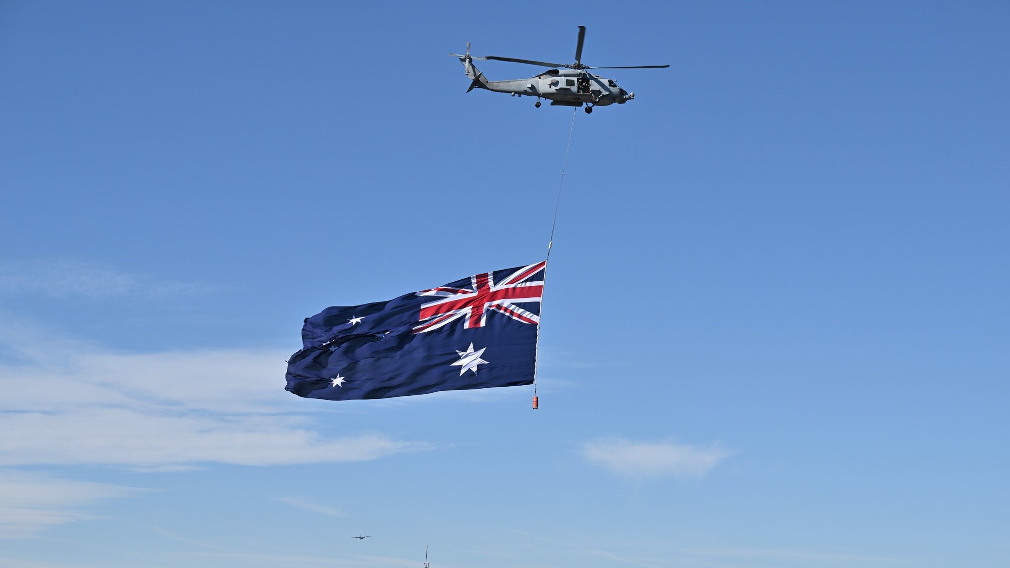 epa10430059 An army helicopter with the Australian flag does a fly over during the National Australia Day 2023 Flag Raising and Citizenship Ceremony in Canberra, Australia, 26 January 2023.  Australia Day is the official national day of Australia, marking the 1788 landing of the First Fleet at Sydney Cove.  EPA/MICK TSIKAS   AUSTRALIA AND NEW ZEALAND OUT