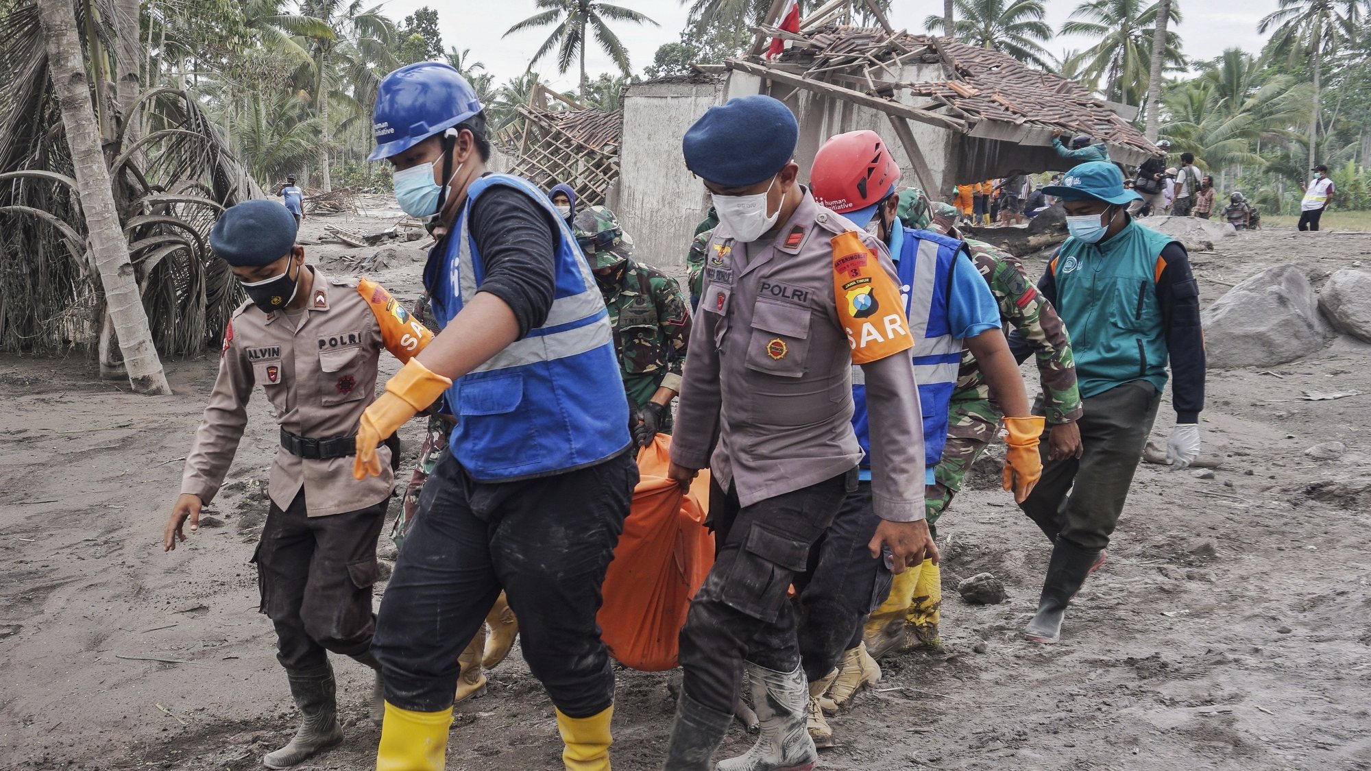 epaselect epa09625049 Rescuers carry the body of a victim at an area affected by the eruption of Mount Semeru in Lumajang, East Java, Indonesia, 06 December 2021. The volcano erupted on 04 December, killing at least 14 people and leaving dozens of others injured.  EPA/AMMAR