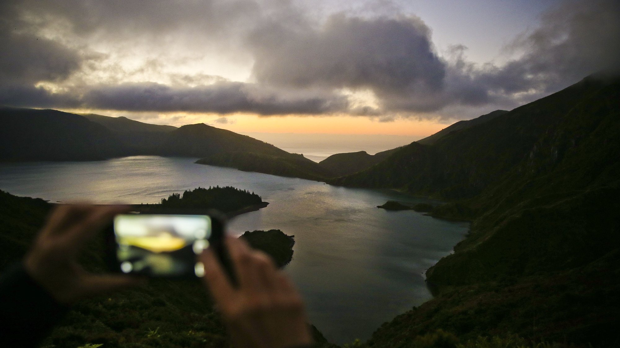 A picture made available on 14 October 2016 shows a woman taking a picture of Lagoa do Fogo (Lagoon of Fire), Sao Miguel island, Azores, Portugal, 13 October 2016. The archipelago composed by 9 islands in the Atlantic ocean has 228,160 voters that will choose 57 deputies for the Azorean Parliament. The regional elections are held on 16 October. MARIO CRUZ/LUSA
