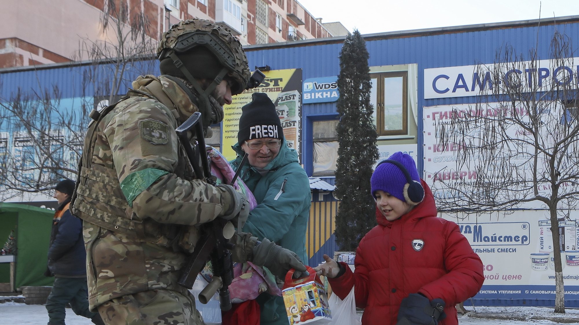 epa10397091 A Ukrainian serviceman hands candies to a girl at a street of Bakhmut, Donetsk region, eastern Ukraine, 09 January 2023, amid Russia&#039;s invasion. For months the front-line city of Bakhmut has seen heavy fighting taking place as it has been a key target for Russian forces. Russian troops on 24 February 2022, entered Ukrainian territory, starting a conflict that has provoked destruction and a humanitarian crisis.  EPA/MYKOLA TYMCHENKO