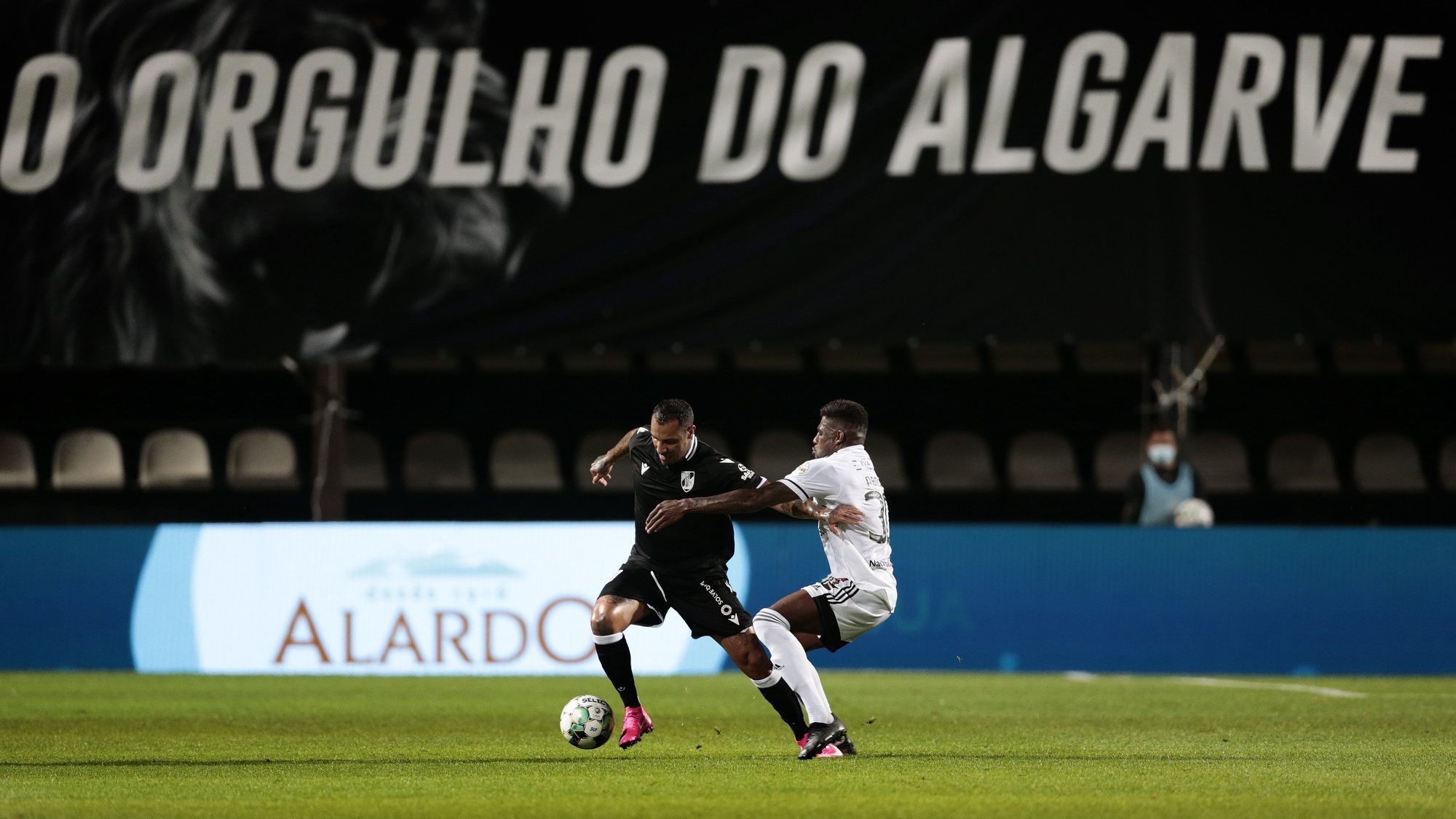 Um jogador do Farense (D), e do Vitória de Guimarães em ação durante o jogo da 31.ª jornada da Primeira Liga de futebol, realizado no Estádio São Luís, em Faro, 06 de maio de 2021. FILIPE FARINHA/LUSA