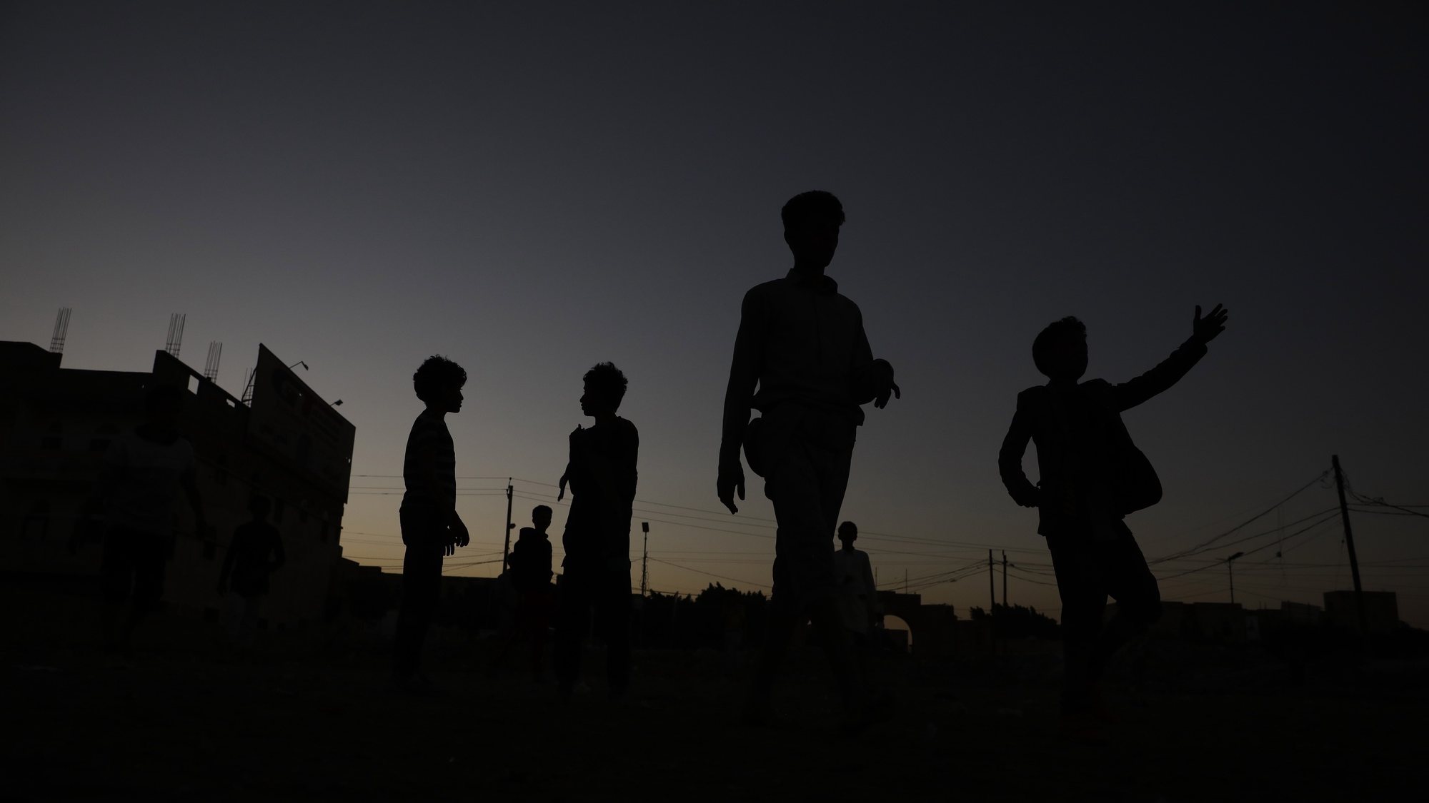 epa10347262 The silhouette of young Yemenis playing soccer at a field of a neighborhood in Sana&#039;a, Yemen, 03 December 2022. Soccer is one of the most popular sports in Yemen. The national football league has been suspended in the Houthis-controlled main cities, including the capital Sana&#039;a, after the war erupted in March 2015, but football matches are being played by young people and children in neighborhoods.  EPA/YAHYA ARHAB