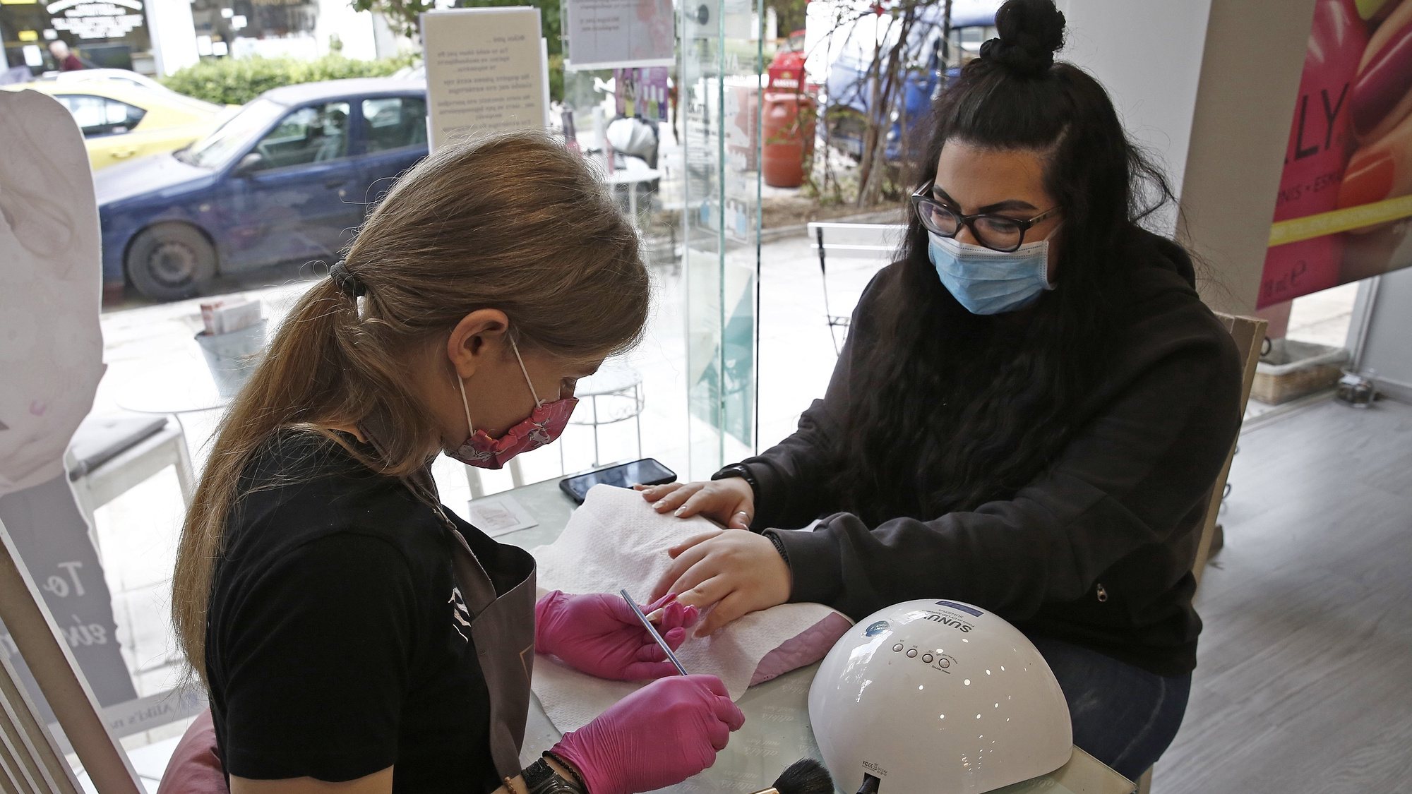 epa08400012 Employees and clients, wear protective face masks, in a beauty shop in Athens, Greece, 04 May 2020. The Greek government gradually eases the restriction measures, taken against the spread of the coronavirus Covid19 pandemic, as of 04 May, lifting most restrictions on the citizens&#039; movement and allowing retail stores and businesses to operate in stages.  EPA/ALEXANDROS VLACHOS