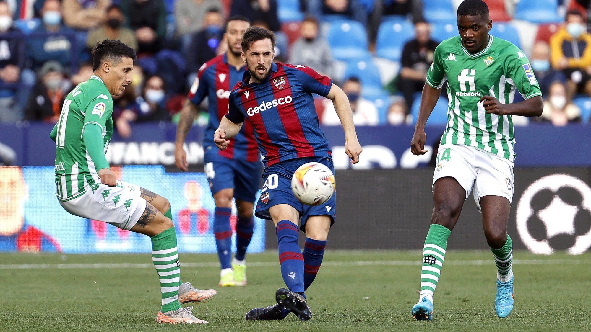 epa09753357 Levante&#039;s Jorge Miramon (C) in action against Betis players Cristian Tello (L) and William Carvalho (R) during the Spanish LaLiga soccer match between Levante UD and Real Betis in Valencia, Spain, 13 February 2022.  EPA/Kai Foersterling