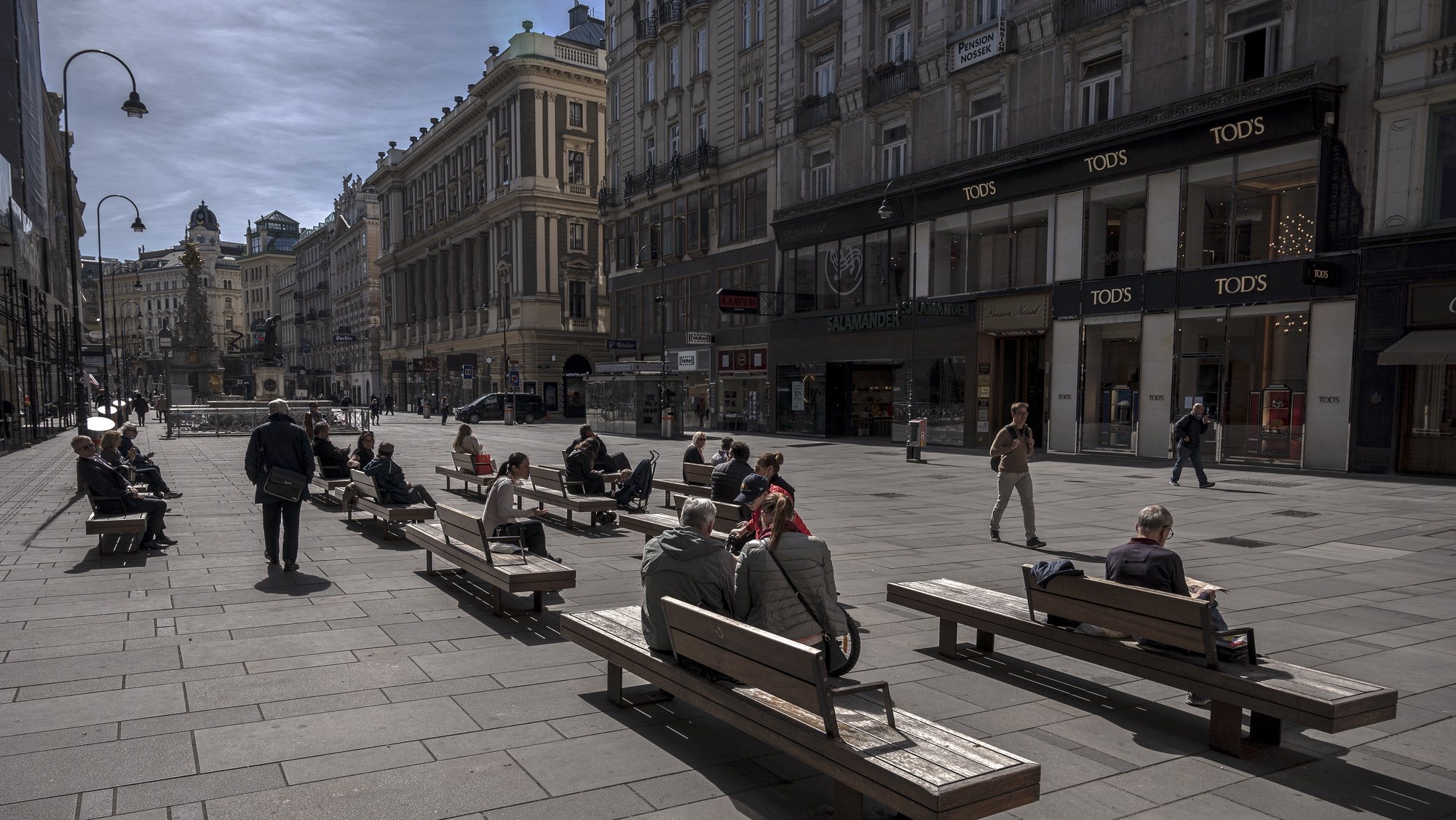 epa08366688 People sit on benches at the Graben shopping street in Vienna, Austria, 16 April 2020. Non essential stores with a shop area under 400 square meters, hardware stores, garden centres and federal parks are allowed to reopen under strict safety measures to slow down the ongoing pandemic of the COVID-19 disease caused by the SARS-CoV-2 coronavirus since 14 April 2020. The government has ordered to wear face masks in supermarkets, pharmacies, various kind of opened shops, public transportation and car pools.  EPA/CHRISTIAN BRUNA