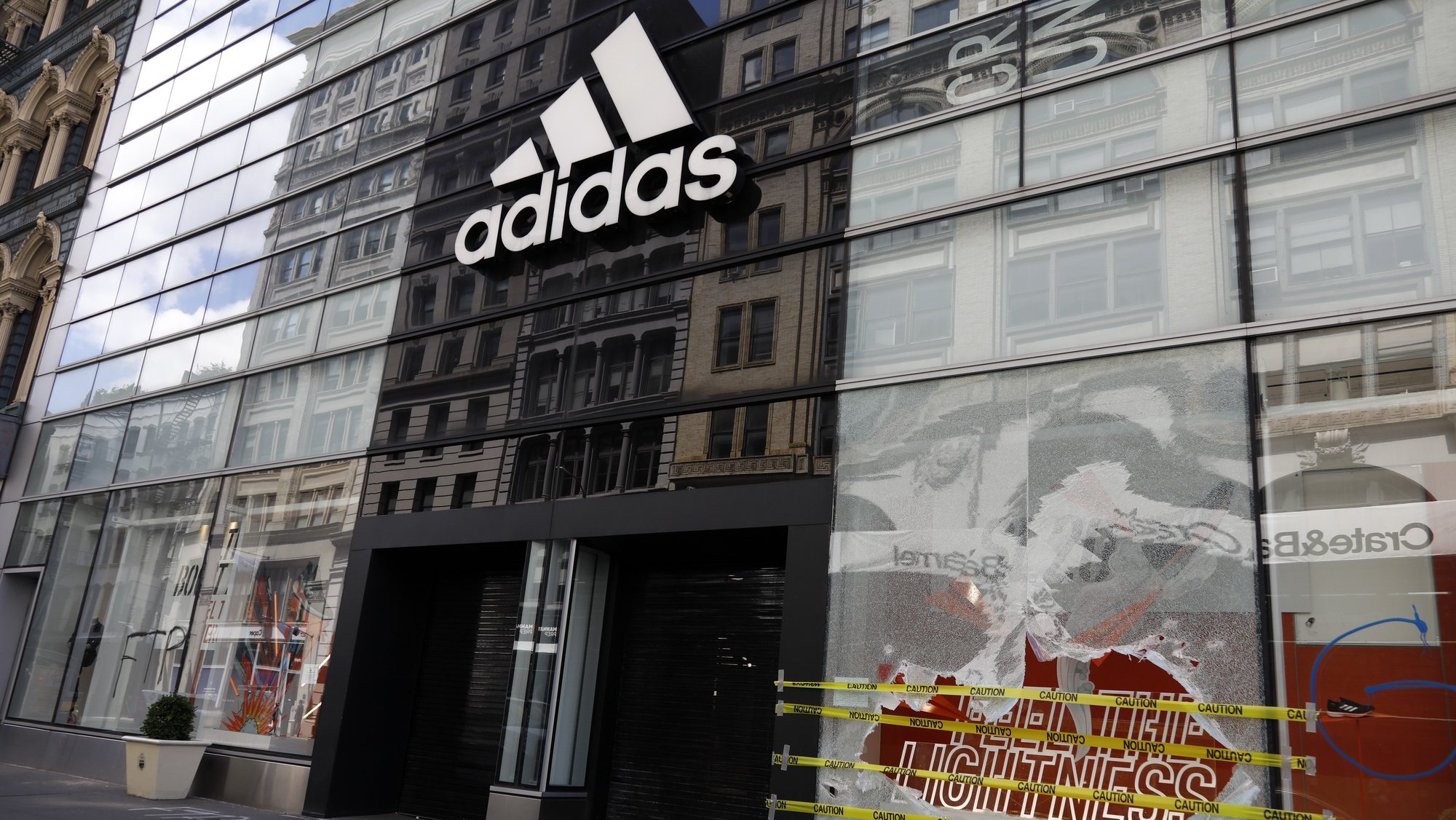 epa08459077 The Adidas Originals store shows a broken window on West Broadway after looting riots a night earlier as part of the response by protesters to George Floyd&#039;s death, in New York, New York, USA, 01 June 2020. A bystander&#039;s video posted online on 25 May, shows George Floyd pleading with arresting officers that he couldn&#039;t breathe as an officer knelt on his neck. The unarmed black man soon became unresponsive, and was later pronounced dead. According to reports on 29 May, Derek Chauvin, the police officer at the center of the incident, has been taken into custody and charged with murder in the death of George Floyd.  EPA/JASON SZENES