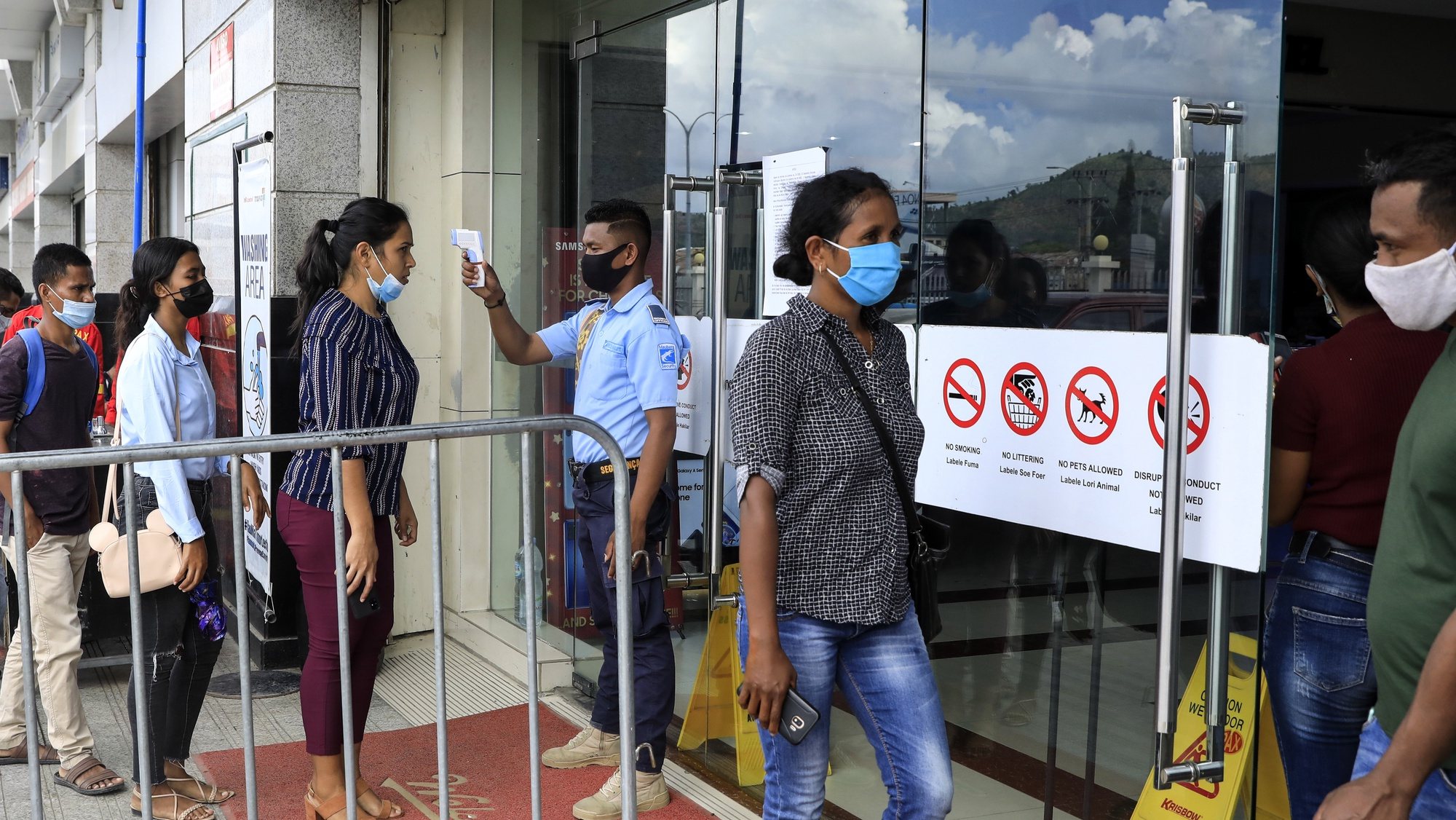 epa08936477 A security guard checks the body temperature of customers before they enter a shopping mall amid the ongoing COVID-19 disease pandemic in Dili, East Timor, also known as Timor Leste, 11 January 2021 (issued 14 January 2021). According to reports Timor Leste is considered successful in overcoming the pandemic and recorded as the second-smallest outbreak in Southeast Asia after Laos. Timor Leste has 49 cases with zero death while the neighbouring country Indonesia is struggling as one of the worst outbreaks in the region. The country imposed a state of emergency a week after the Catholic-majority nation reported its first case on 21 March 2020, and enforced strict border controls.  EPA/ANTONIO DASIPARU
