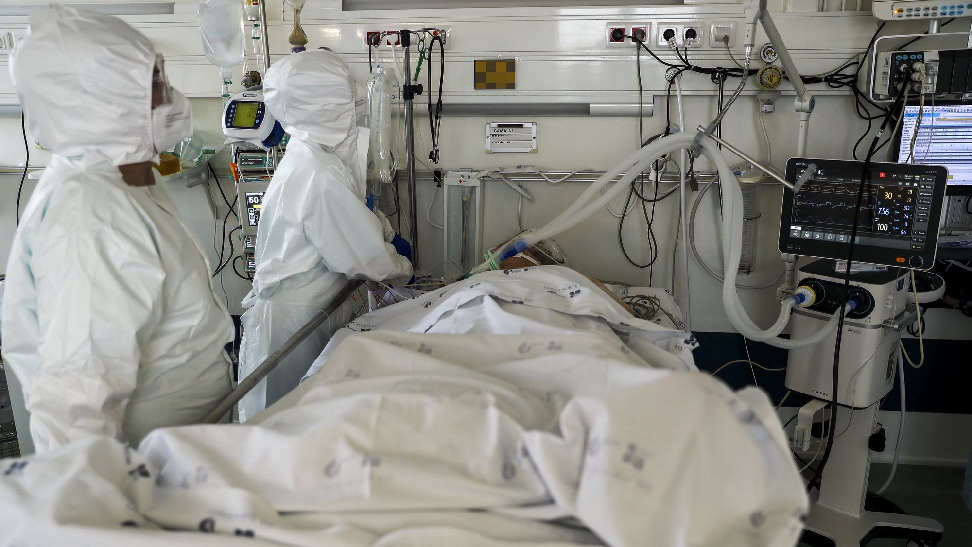 Dois elementos da equipa médica cuidam de uma paciente hospitalizado na Unidade de Cuidados Intensivos covid-19