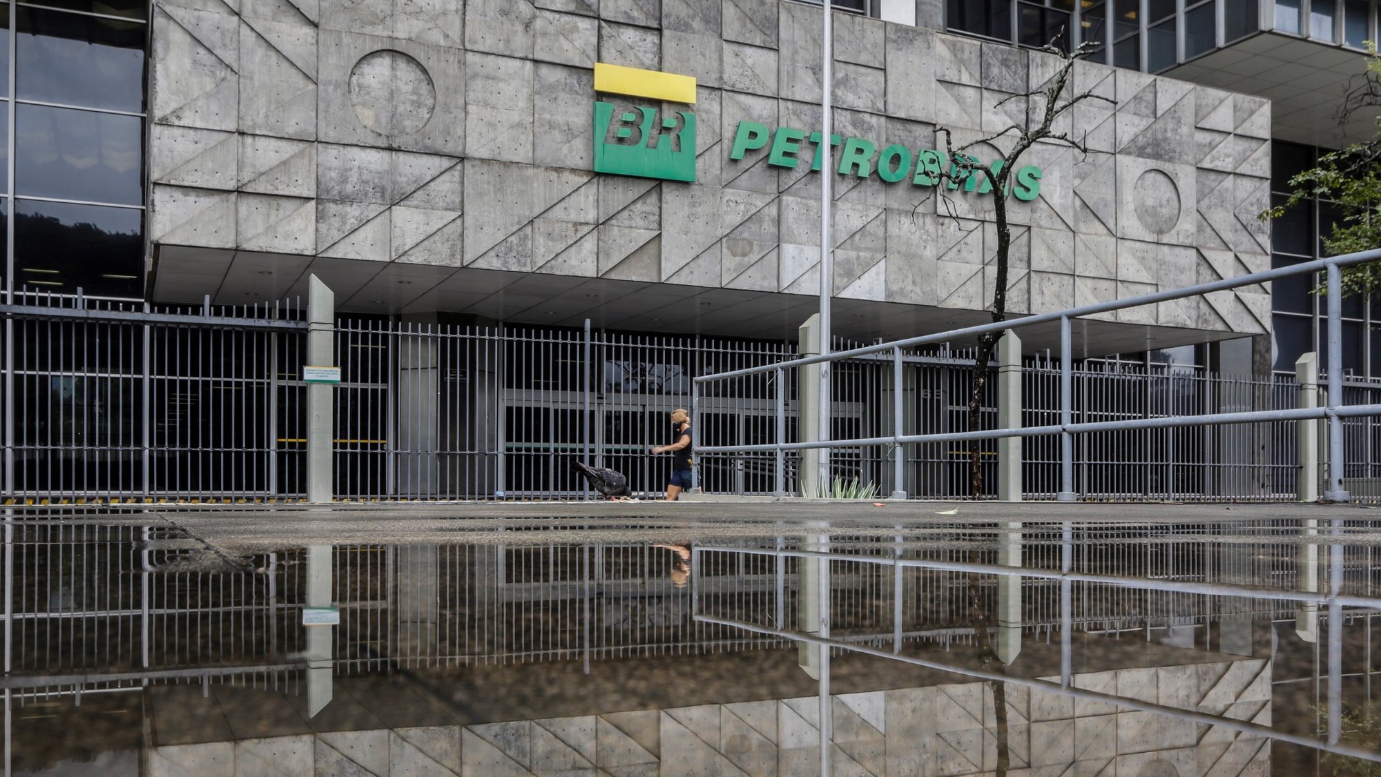 epa09030272 A person walks in front of the Petrobras headquarters in Rio de Janeiro, Brazil, 22 February 2021. The Brazilian president has opened a new crisis in Petrobras by announcing a retired Army general as the new president of the state oil company, which sank in the stock market, and raised doubts about his commitment to economic liberalism.  EPA/Antonio Lacerda