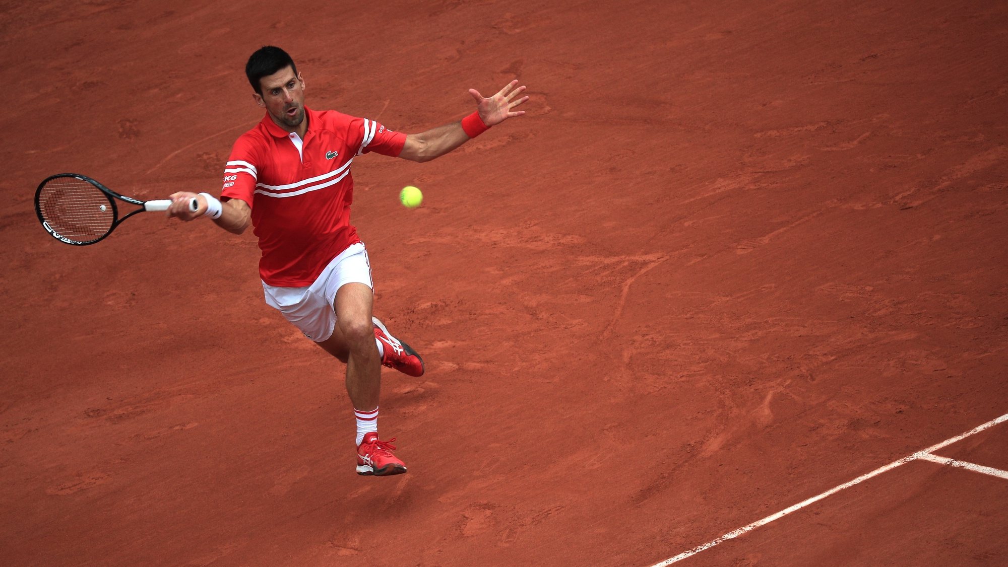 epa09249485 Novak Djokovic of Serbia in action against Ricardas Berankis of Lithuania during their third round match at the French Open tennis tournament at Roland Garros in Paris, France, 05 June 2021.  EPA/CHRISTOPHE PETIT TESSON