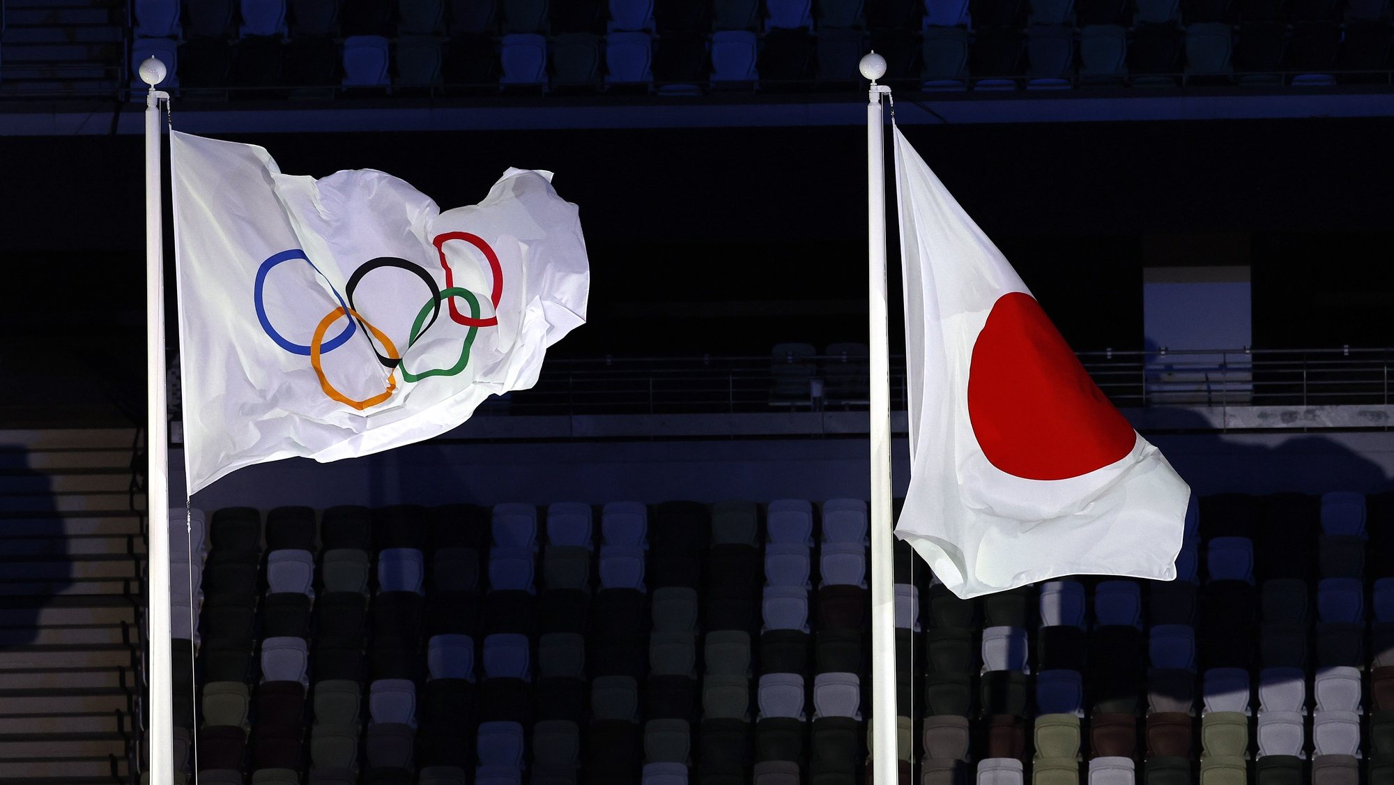 epa09360022 The Olympic flag flies next to the Japanese flag during the Opening Ceremony of the Tokyo 2020 Olympic Games at the Olympic Stadium in Tokyo, Japan, 23 July 2021.  EPA/RUNGROJ YONGRIT