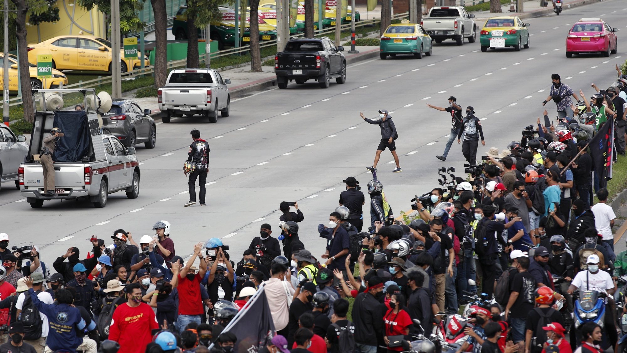 epa09434984 Anti-government protesters react to police officers (L) during a car mob rally calling for the resignation of the prime minister at a street in Bangkok, Thailand, 29 August 2021. Thousands of anti-government protesters ride their vehicles and blaring horns in a car mob convoy calling for the ouster of the prime minister over the government&#039;s failure in handling the COVID-19 crisis.  EPA/RUNGROJ YONGRIT