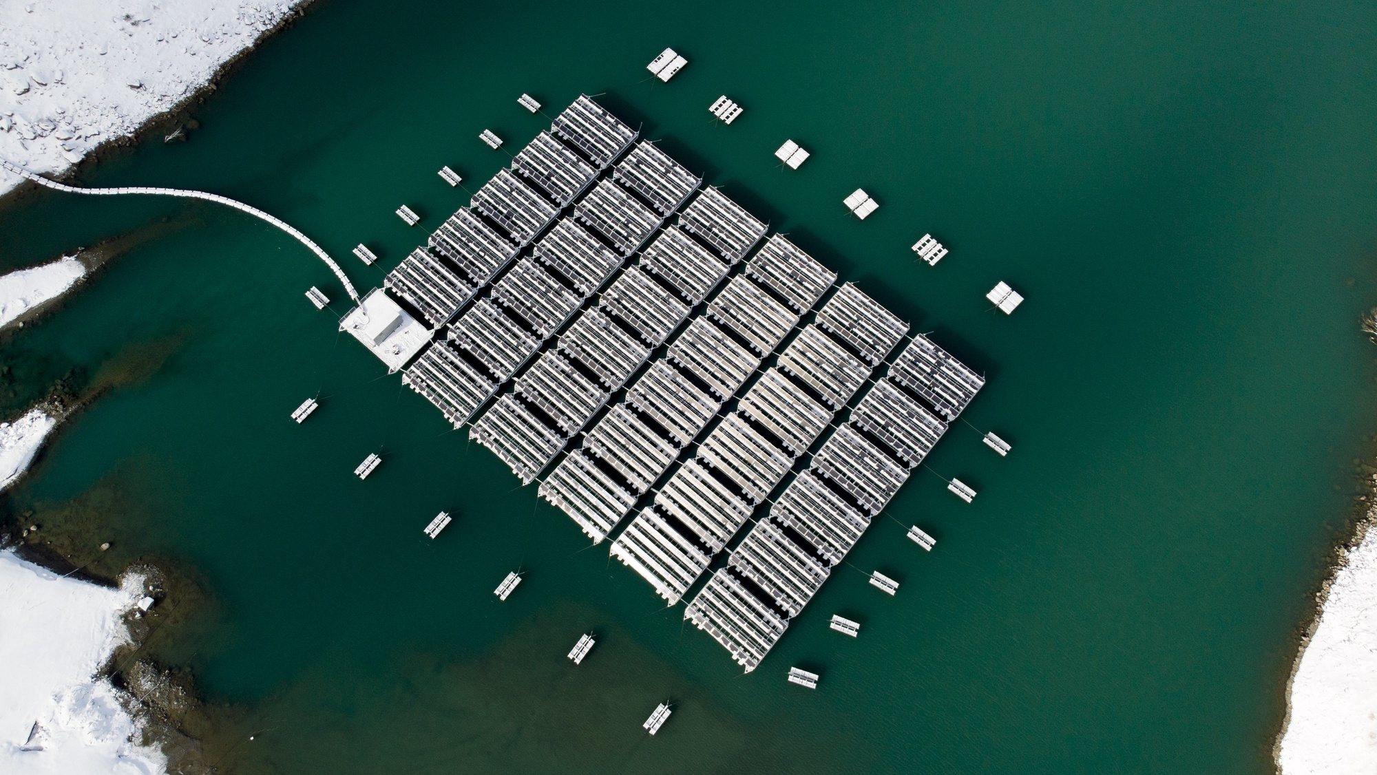 epaselect epa08007491 An image taken with a drone shows floating barges with solar panels on the &#039;Lac des Toules&#039;, an alpine reservoir lake, next to snow covered mountains, in Bourg-Saint-Pierre, Switzerland, 18 November 2019 (issued 19 November 2019). The floating solar panel station consist of 36 floating barges featuring 2,240 square meters of solar cells targeting to deliver 800,000 kilowatt-hour per year, the annual power consumption of approximately 220 homes.  EPA/LAURENT DARBELLAY IMAGE TAKEN WITH A DRONE; EDITORIAL USE ONLY; ONE TIME USE ONLY, NO SALES NO ARCHIVES  EDITORIAL USE ONLY/NO SALES/NO ARCHIVES