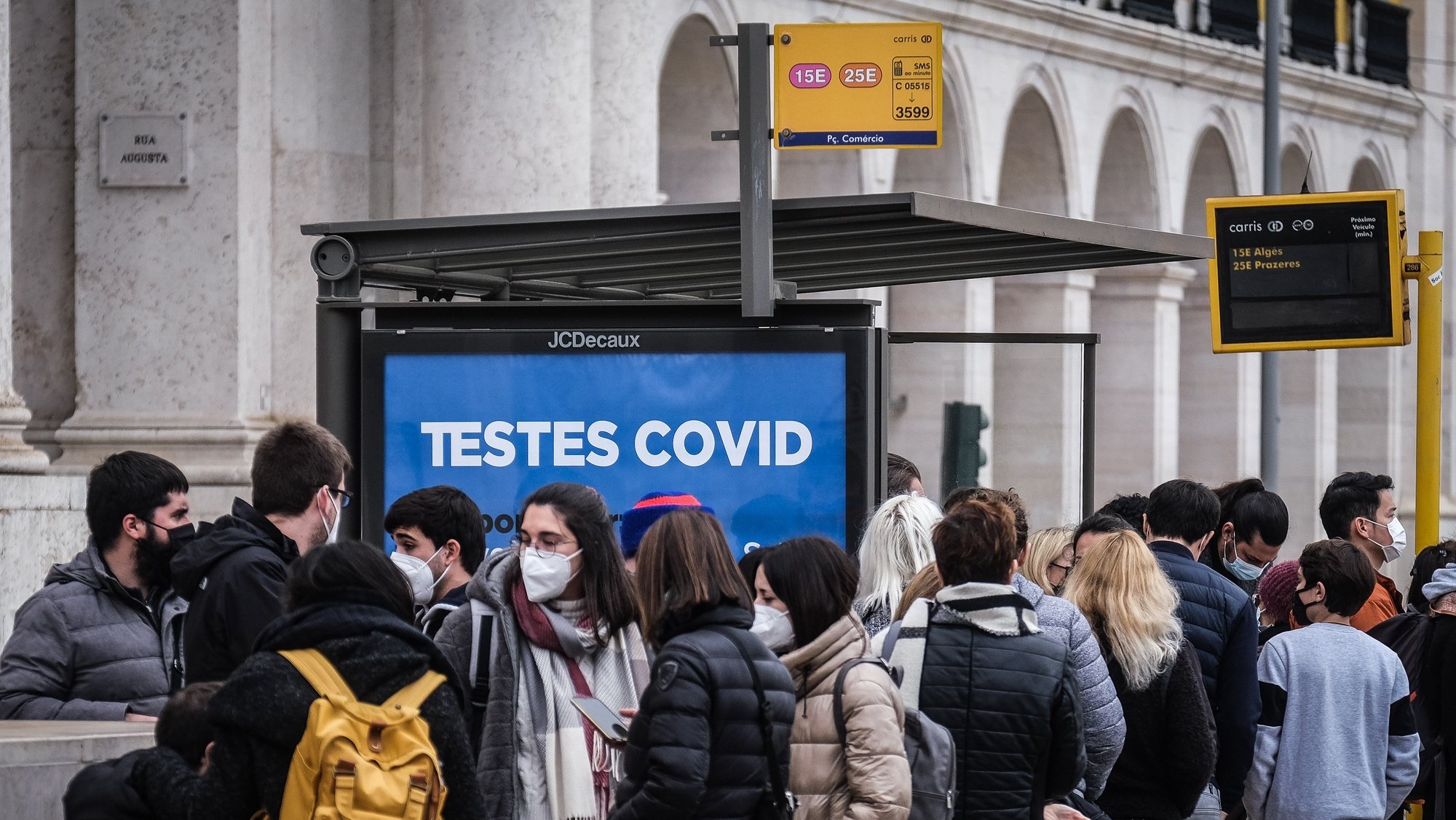People waiting for a bus next to a sign advertising covid testing in Lisbon, Portugal, 30 December 2021. Yesterday, Portugal registered 26,867 new covid-19 infections, a new high since the start of the pandemic. Due to the surge of positive cases and the rise of the Omicron variant Portugal&#039;s government decided to implement restrictive measures such as closing schools, bars and clubs. MARIO CRUZ/LUSA