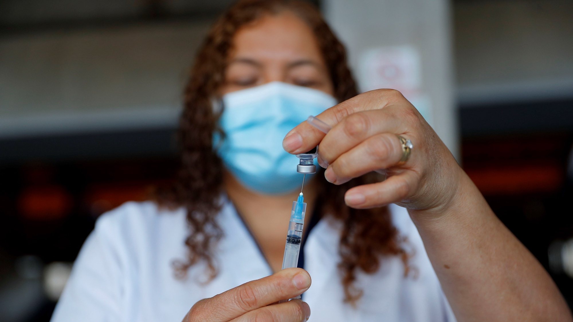A health worker prepares a vaccine against covid-19 during a vaccination campaign, in Tegucigalpa, Honduras, 31 December 2021. EPA/Gustavo Amador