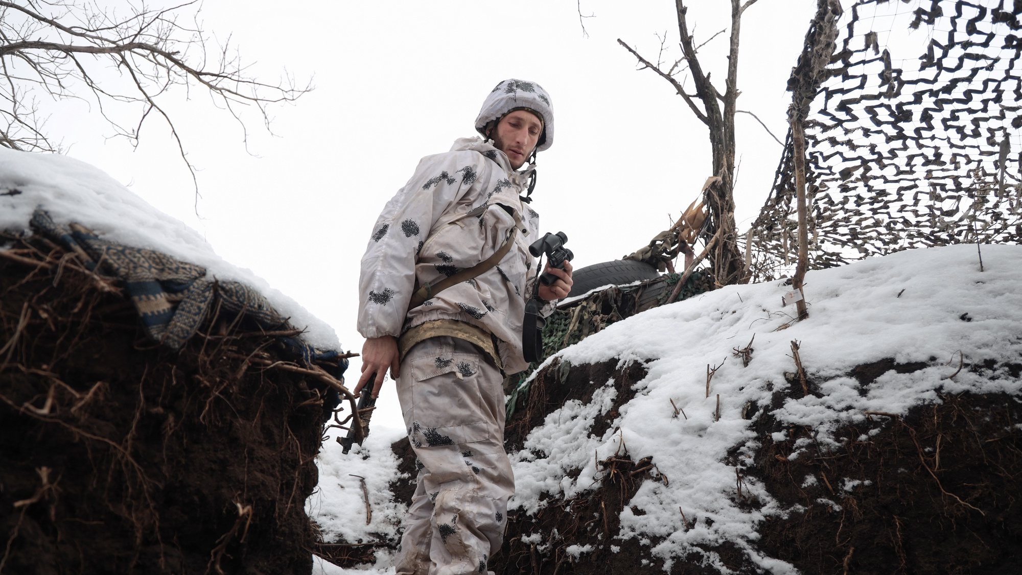 Um soldado ucraniano verifica a situação nas posições da linha da frente, não muito longe de onde os militares russos controlam a cidade de Horlivka, Ucrânia, 31 de janeiro de 2022