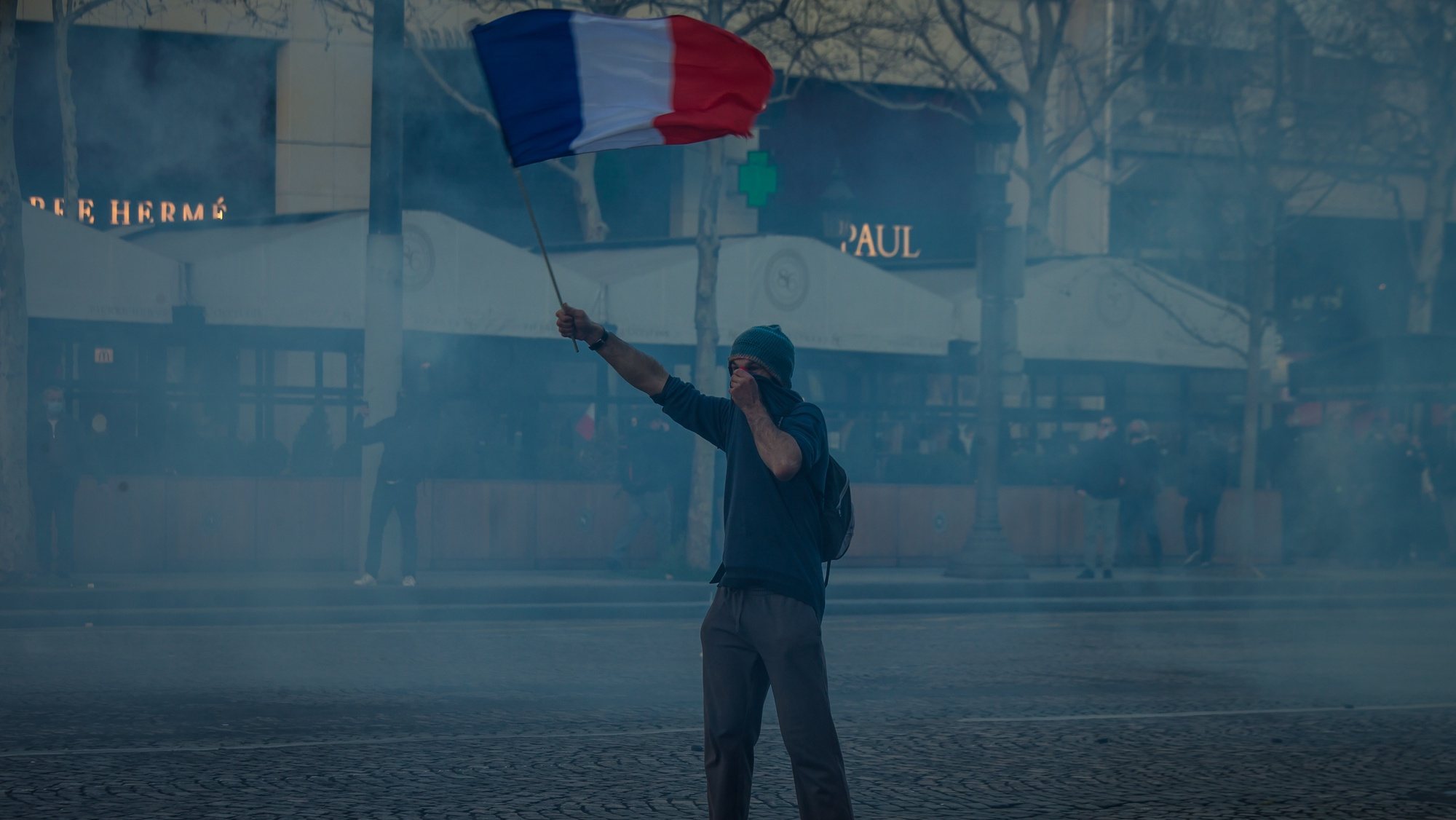 epa09750518 A protester waves a French flag as the so-called &#039;Freedom Convoy&#039; members are trying to block the traffic, in Paris, France, 12 February 2022. Paris police have prohibited the convoy, as announced by the capital&#039;s prefect on 10 February. A series of convoy demonstrations has been taking place in France to call for the lifting of all Covid-19-related restrictions and mandates, in light of the ongoing protest in Canada, where truck drivers have been rallying against the government-imposed mandatory Covid-19 vaccine to enter the country.  EPA/CHRISTOPHE PETIT TESSON