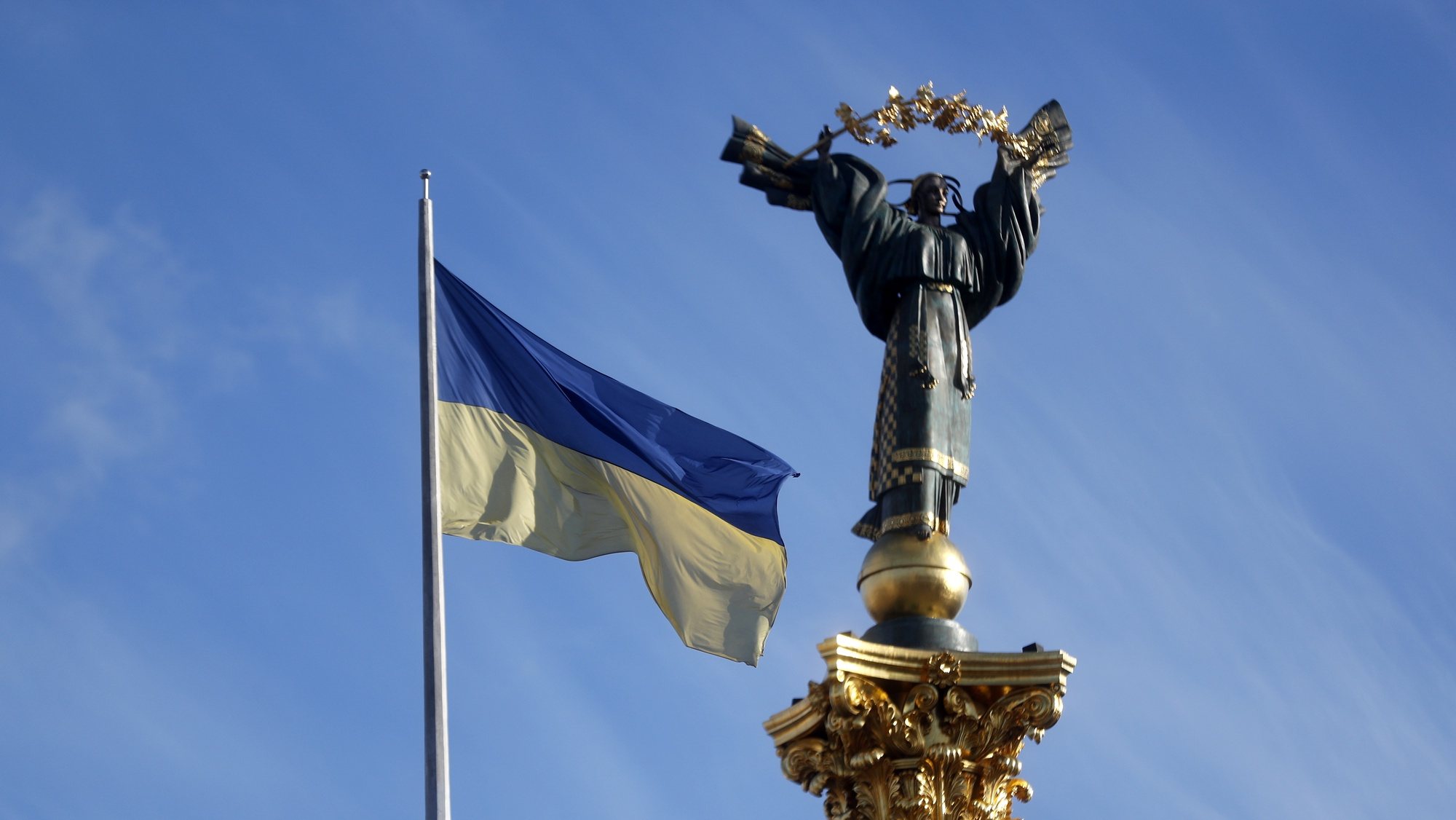 epa09786831 A national flag waves in front of the Independence monument in the central square of Kiev, Ukraine, 26 February 2022. Russian troops launched a major military operation on Ukraine on 24 February, after weeks of intense diplomacy and the imposition of Western sanctions on Russia aimed at preventing an armed conflict in Ukraine. Martial law was introduced in Ukraine, with explosions heard in many cities, including Kiev.  EPA/ZURAB KURTSIKIDZE