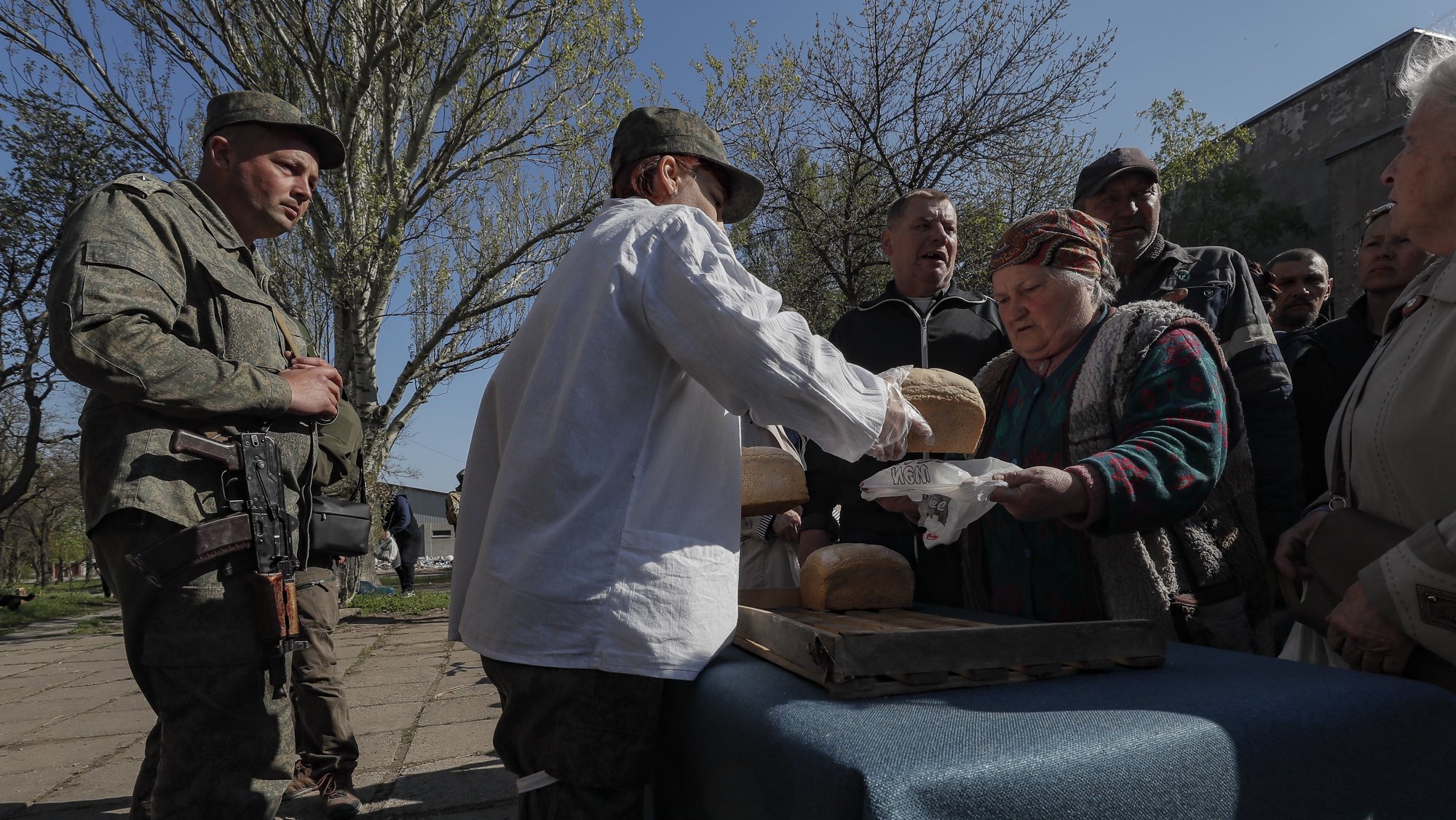 epa09917331 A picture taken during a visit to Luhansk organized by the Russian military shows servicemen of the self-proclaimed Donetsk People&#039;s Republic distribute bread to local people during distributing humanitarian aid in Mariupol, Ukraine, 29 April 2022. According to Eduard Basurin, spokesman of the self-proclaimed Donetsk People&#039;s Republic (DPR): &#039;after two months of continued hostility in the city, the main battles in Mariupol are over&#039;. On 24 February Russian troops had entered Ukrainian territory in what the Russian president declared a &#039;special military operation&#039;, resulting in fighting and destruction in the country, a huge flow of refugees, and multiple sanctions against Russia.  EPA/SERGEI ILNITSKY