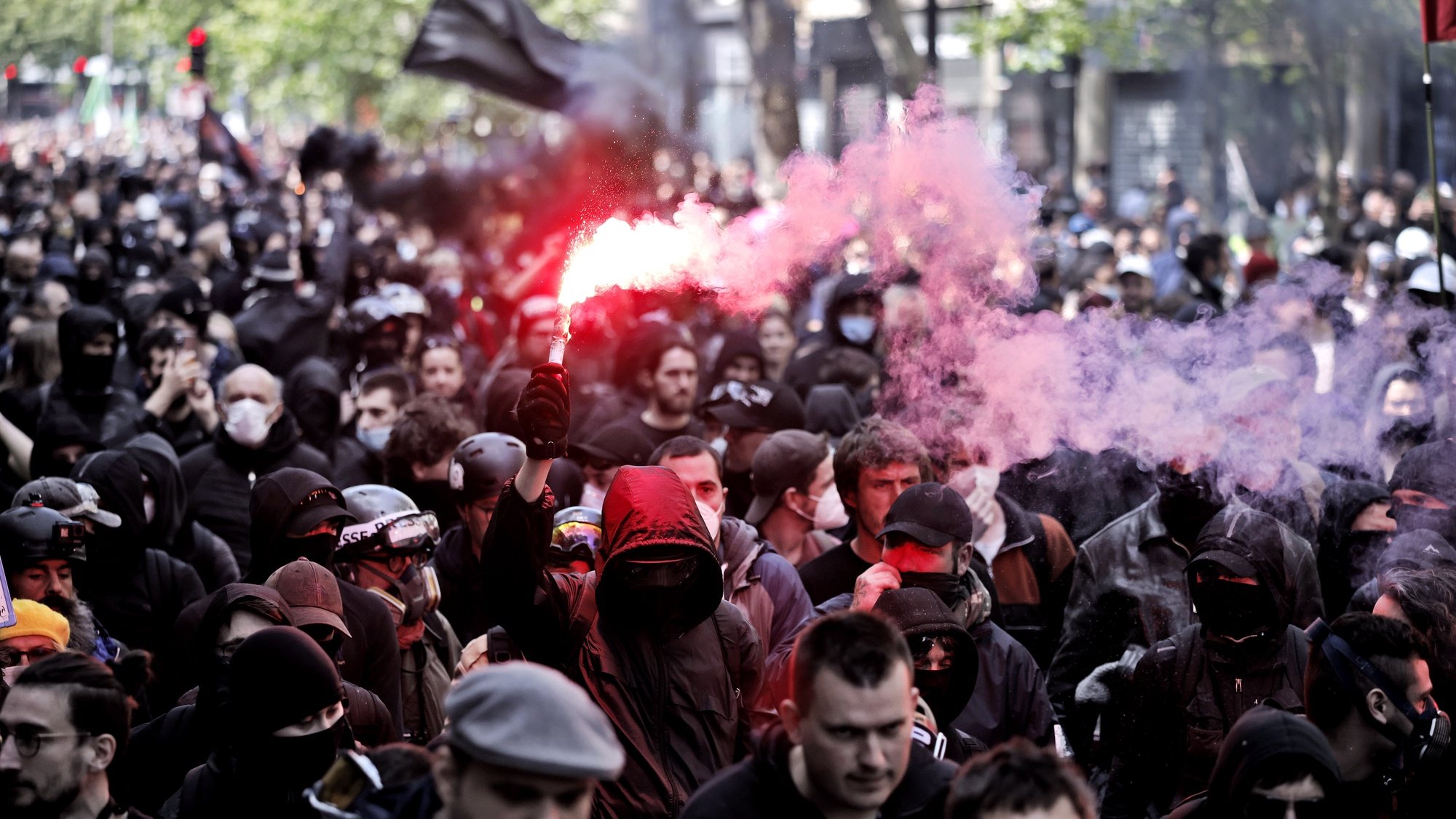 epa09920389 Demonstrators light red flares as they take part in the annual May Day march in Paris, France, 01 May 2022. Labour Day, also known as International Workers&#039; Day or May Day, is observed annually on 01 May worldwide to celebrate the economic and social achievements of workers as well as fight for laborers rights.  EPA/YOAN VALAT