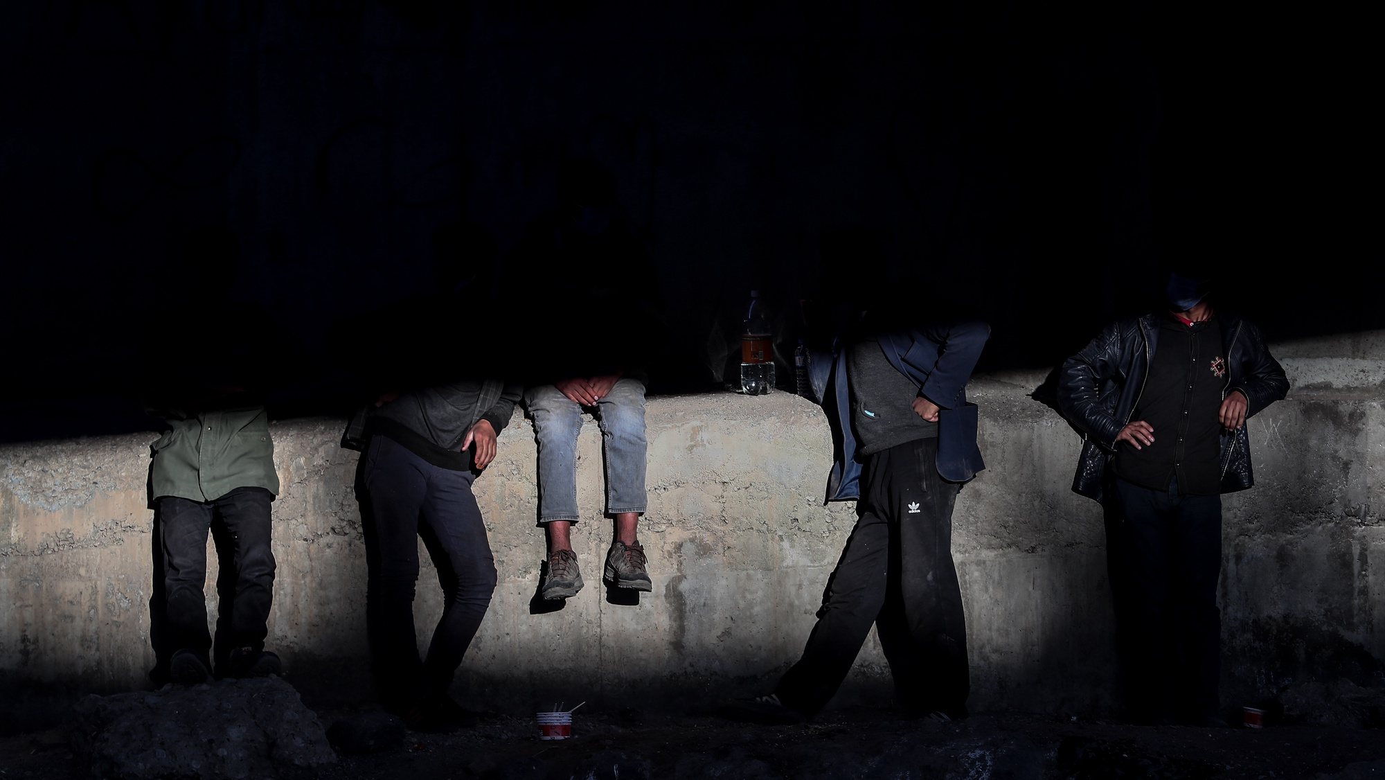 epa09623482 A group of people rest under a bridge near a railway in the Turkish city of Van after crossing the Iran-Turkey border, 02 June 2021. People smuggled into the country wait for days to be transferred by smugglers to Diyarbakir city to reach west Turkey. The city of Van, on the Turkish-Iranian border, is one of the points at which human smuggling can be easily spotted. Smugglers charge between 600 or 1,000 US dollars per person, depending on the security situation at the border.  EPA/SEDAT SUNA