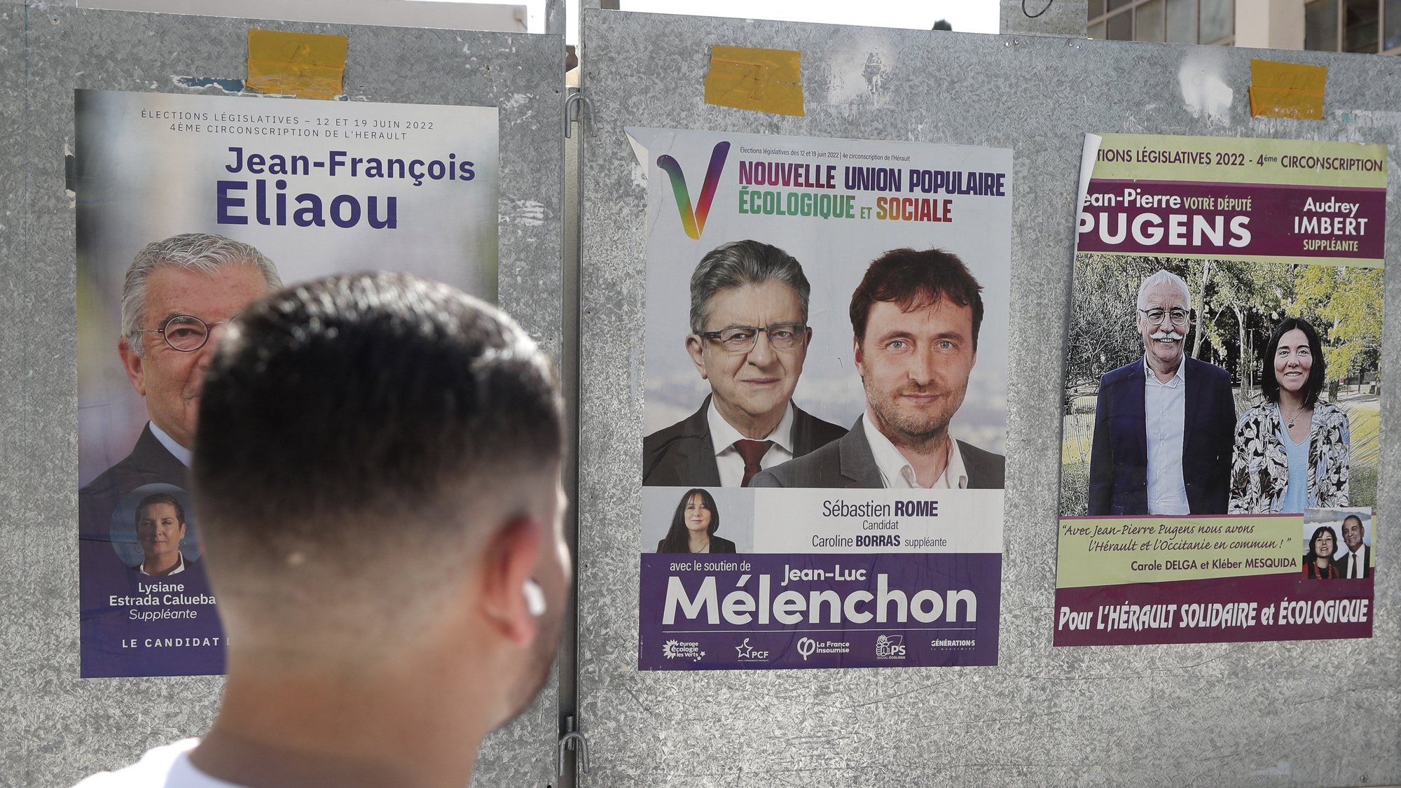 epa10014669 A man looks at legislative election posters in Gignac, France, 15 June 2022. The legislative elections will be held on 12 and 19 June 2022 to elect the 577 members for the National Assembly of the French Republic.  EPA/GUILLAUME HORCAJUELO