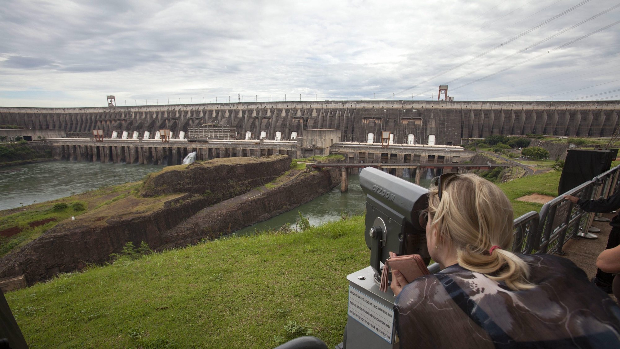epa04628919 A picture made available on 20 February 2015 shows a tourist observing the binational hydroelectric power station of Itapu, in the border of Brazil and Paraguay, on 11 February 2015. President of binational hydroelectric power station of Itapu, Jorge Miguel Samek said the hydroelectric power station is prepared for the worst scenary before the current drought in the country and the fear over an eventual energy rationing.  EPA/SEBASTIAO MOREIRA