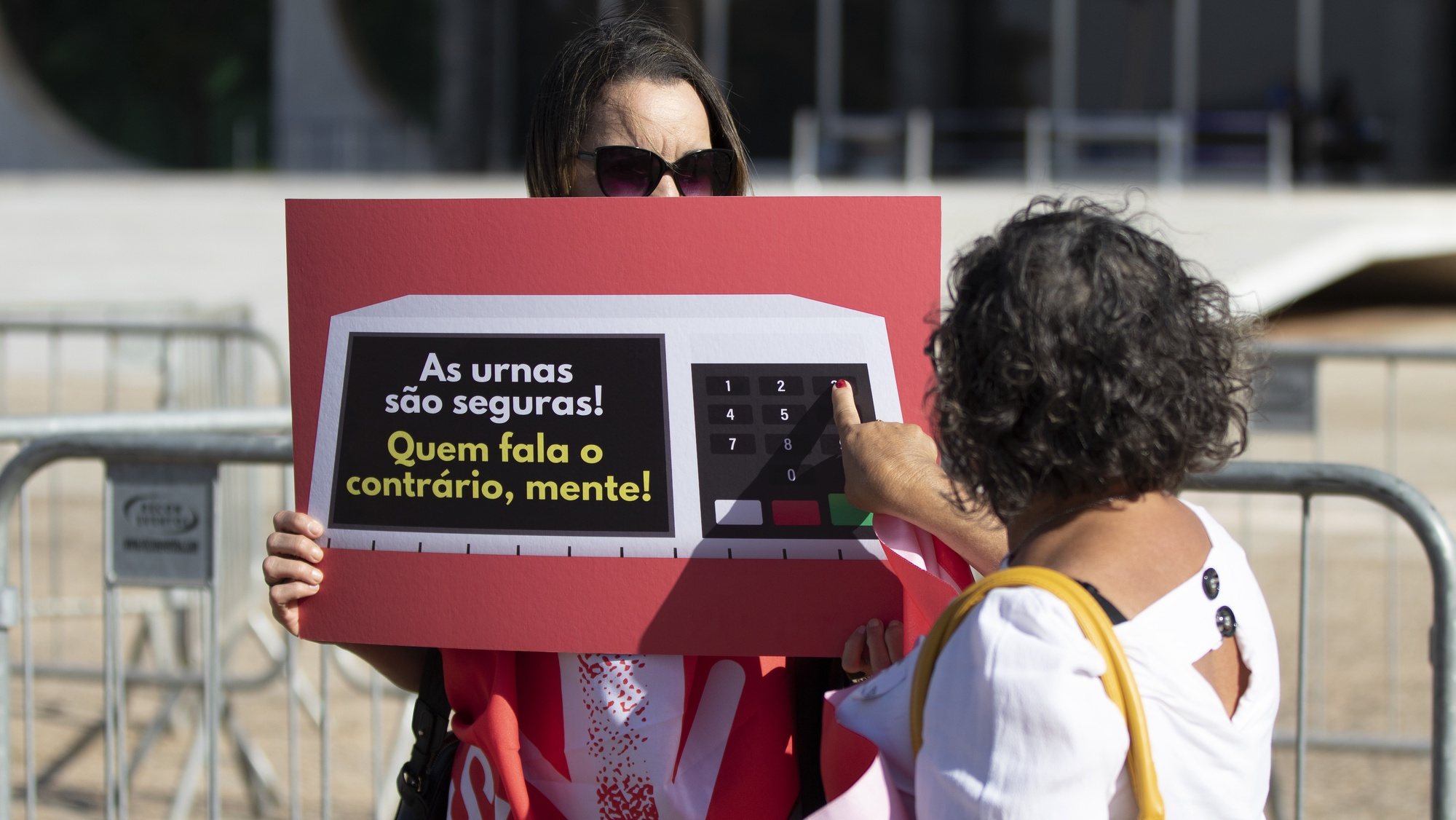 epa10104758 People protest with posters in support of the electoral system in front of the headquarters of the Supreme Court in Brasilia, Brazil, 03 August 2022. This act takes place during the visit by representatives of the Armed Forces who will inspect the source codes of the electronic voting machine in the Multiple Use Room, at the headquarters of the Superior Electoral Court (TSE).  EPA/Joedson Alves