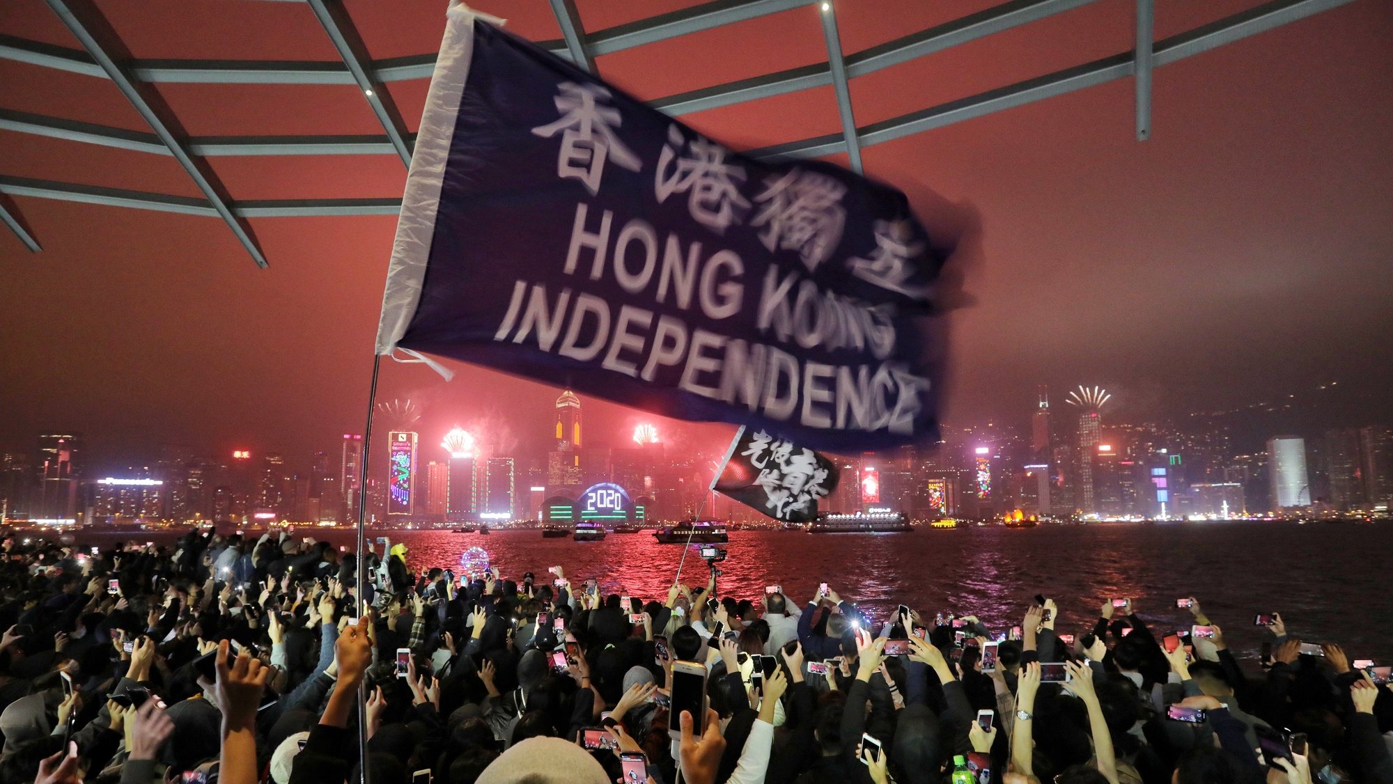 epa08096358 Protesters chant as fireworks explode in Hong Kong along the waterfront on new year&#039;s eve in Tsim Sha Tsui in Hong Kong, China, early 01 January 2020. Hong Kong has been gripped by mass protests for seven months, over a now-suspended extradition bill to China that has morphed into a wider anti-government movement.  EPA/Vivek Prakash