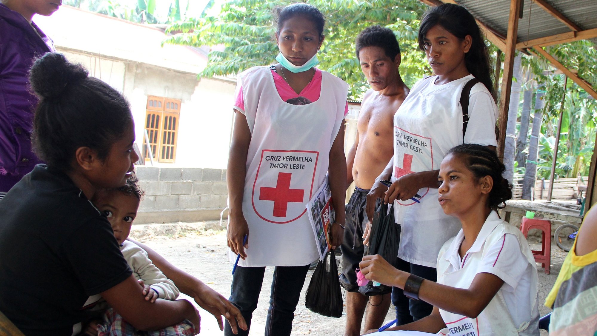 Voluntários da Cruz Vermelha conversam com uma moradora de um dos bairros de Díli, no âmbito da campanha para prevenção do dengue, numa luta que se faz essencialmente pela mudança de mentalidade das pessoas e pela partilha de informação