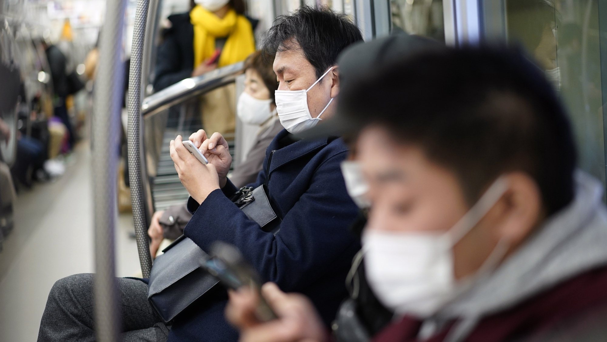 epa08921414 Commuters wearing face masks sit in a subway coach in Tokyo, Japan, 06 January 2021. The Tokyo Metropolitan Government announced that it has confirmed over 1,500 new coronavirus infections in Tokyo, a new record figure. Following the surge in cases number, the government is considering declaring a state of emergency in Tokyo and three surrounding prefectures.  EPA/FRANCK ROBICHON