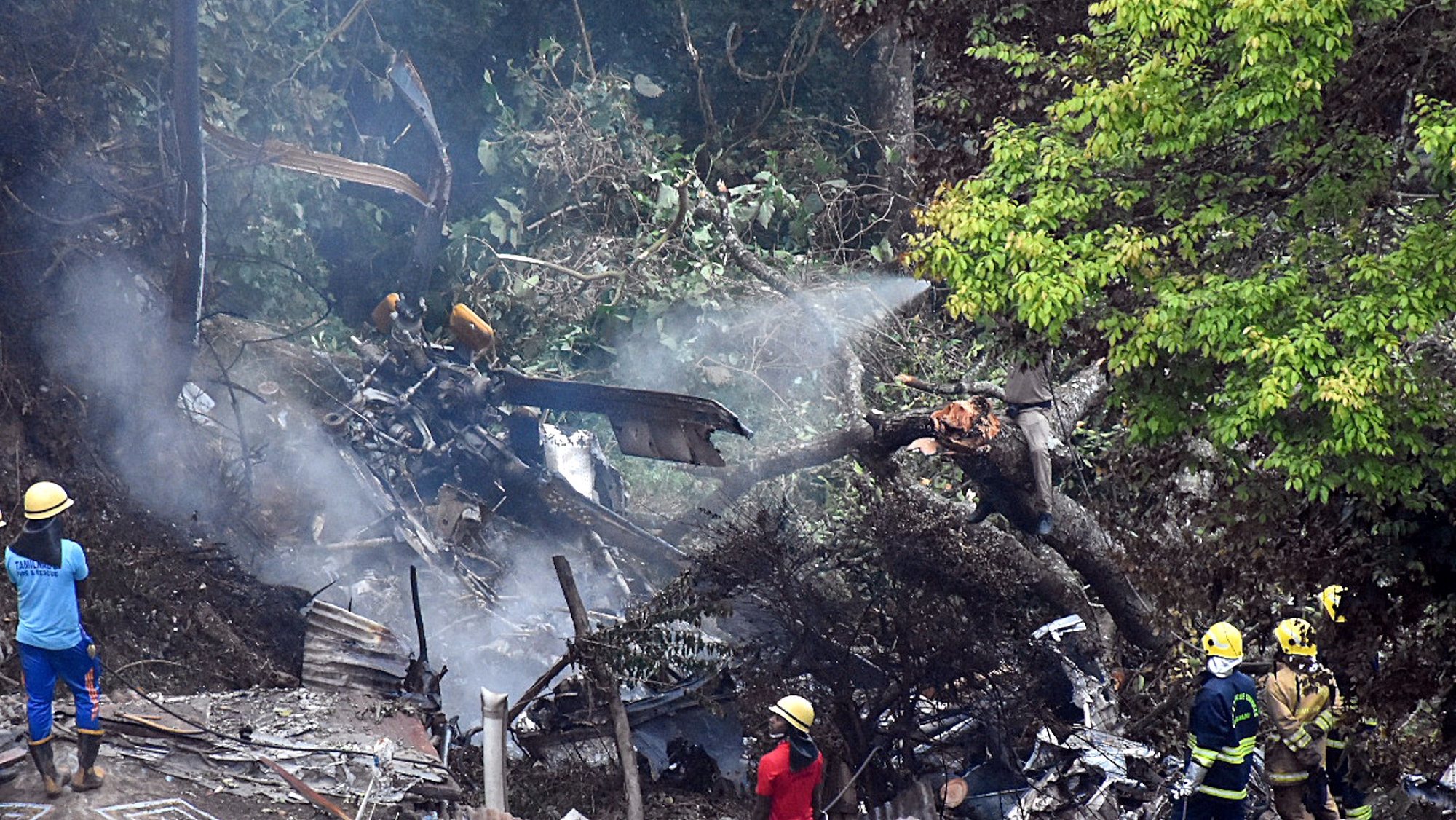 epa09629502 Rescuers work at the crash site after a Mi-17 helicopter carrying chief of defence staff Bipin Rawat and 13 others crashed near Coonoor, Tamil Nadu, India, 08 December 2021. According to the Indian air force statement Gen Bipin Rawat, his wife Madhulika Rawat and 11 others on board have died in the unfortunate accident.  EPA/SHILJA JOSEPH