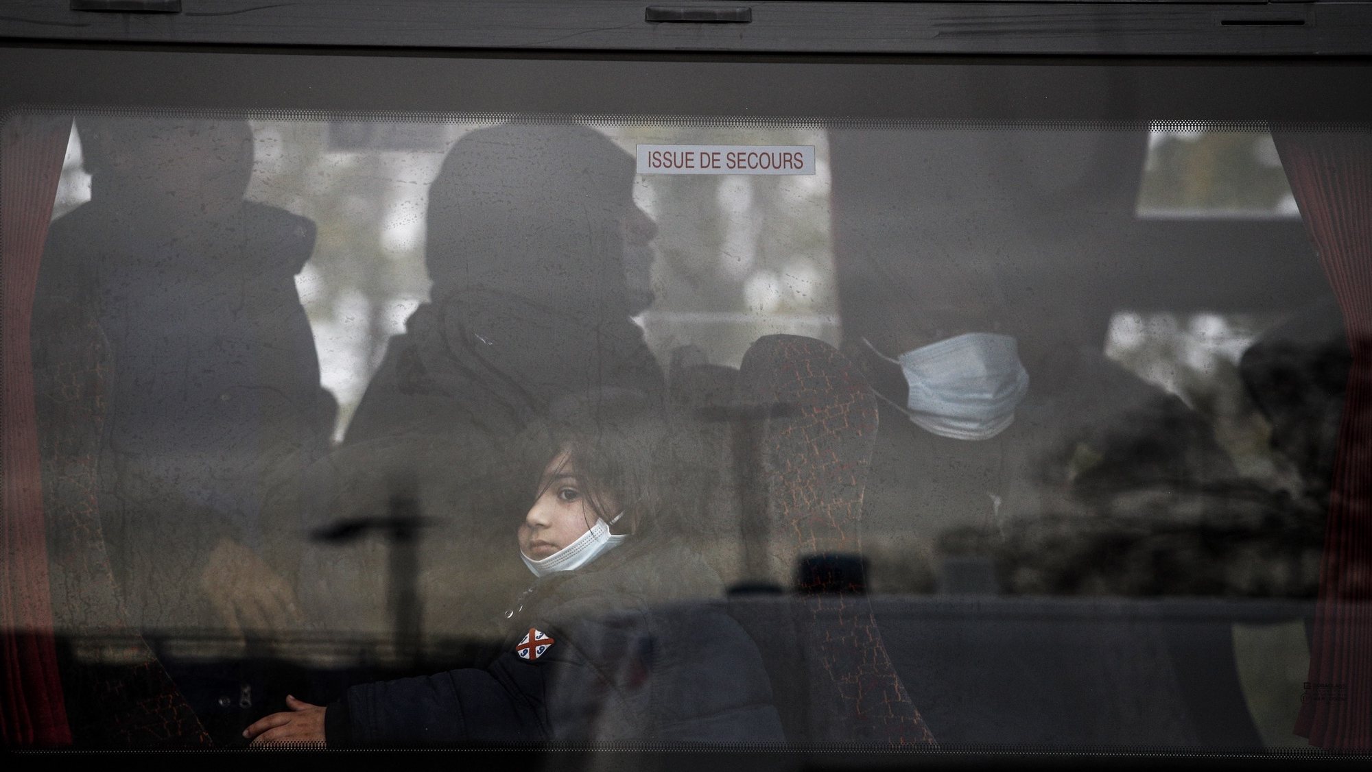 Criança migrante evacuada por autocarro de um campo de refugiados no norte de paris