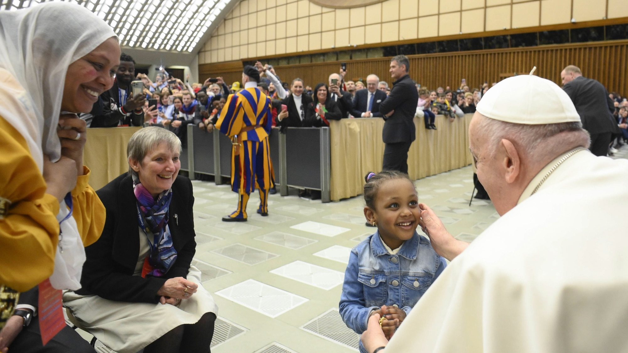 epa10530032 A handout picture provided by the Vatican Media shows Pope Francis (R) meeting refugee families that came to Italy through the humanitarian corridors during an audience in the Paul VI Hall at the Vatican, in Vatican City, 18 March 2023.  EPA/VATICAN MEDIA HANDOUT PHOTO TO BE USED SOLELY TO ILLUSTRATE NEWS REPORTING OR COMMENTARY ON THE FACTS OR EVENTS DEPICTED IN THIS IMAGE HANDOUT EDITORIAL USE ONLY/NO SALES