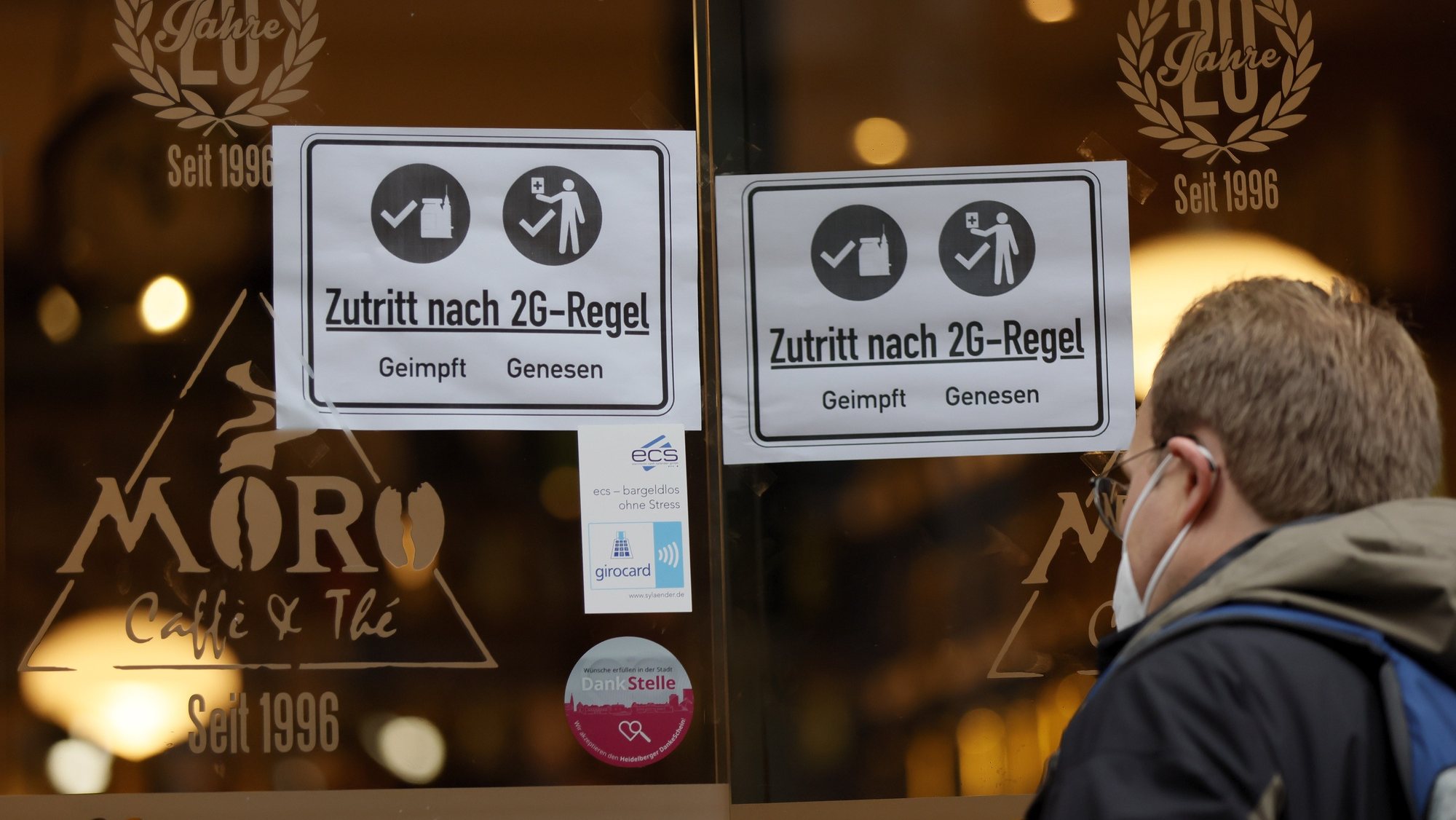 epa09563401 An information sign with letters ‚Access according to 2G rule vaccinated recovered’ on a window at a cafe in the old town of Heidelberg, Germany, 04 November 2021. Due to an increasing number of cases of the pandemic COVID-19 disease caused by the corona virus SARS CoV-2, new nationwide restrictions have been announced to counter a surge in infections.  EPA/RONALD WITTEK