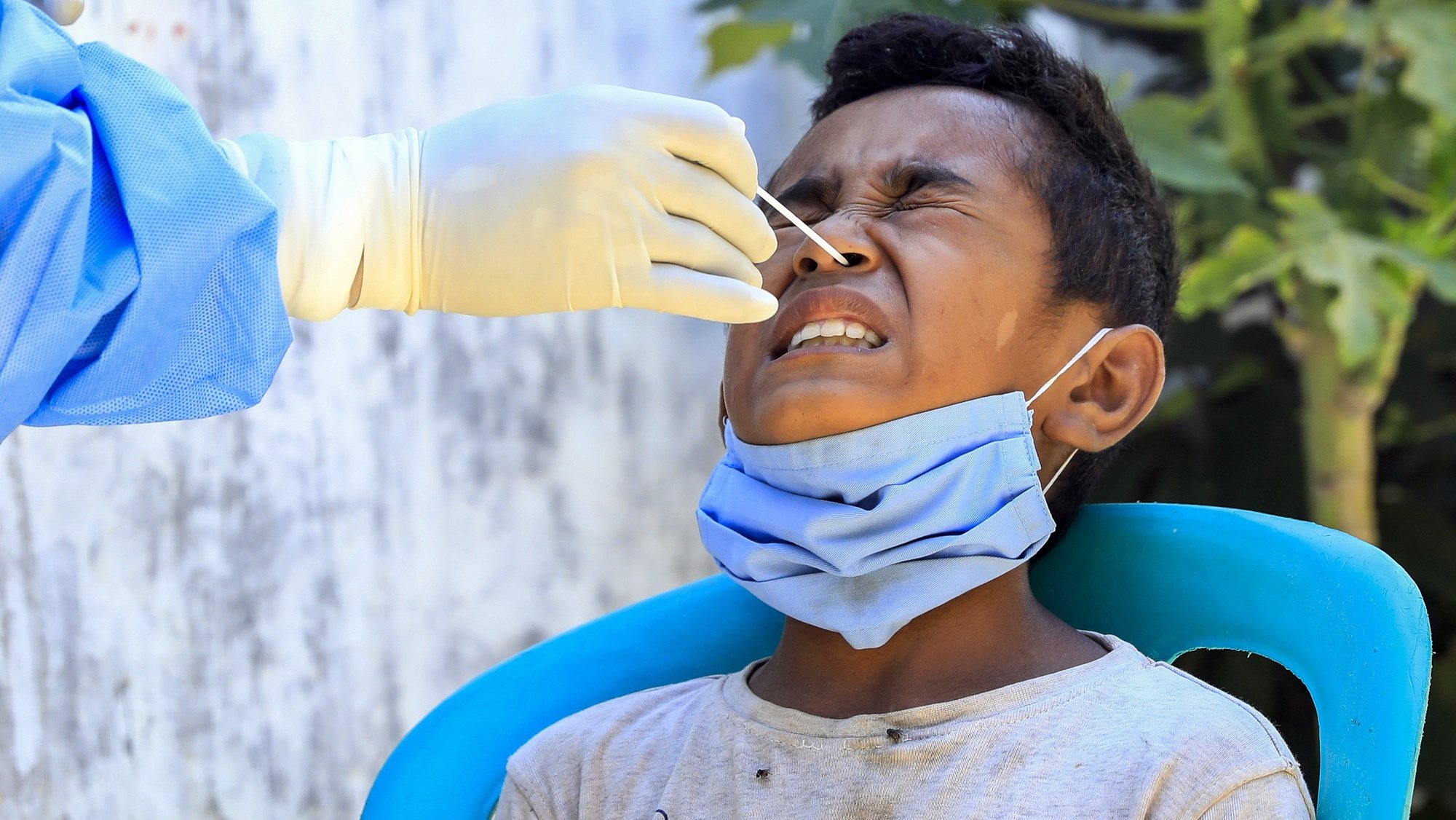 epa09079361 A boy reacts as a healthcare worker collects his specimen samples during a COVID-19 swab test in Dili, East Timor, also known as Timor Leste, 17 March 2021. With less than 300 COVID-19 cases and zero deaths, Timor Leste recorded the second-smallest outbreak in Southeast Asia after Laos. The country imposed a state of emergency a week after the Catholic-majority nation reported its first case on 21 March 2020, and enforced strict border controls.  EPA/ANTONIO DASIPARU