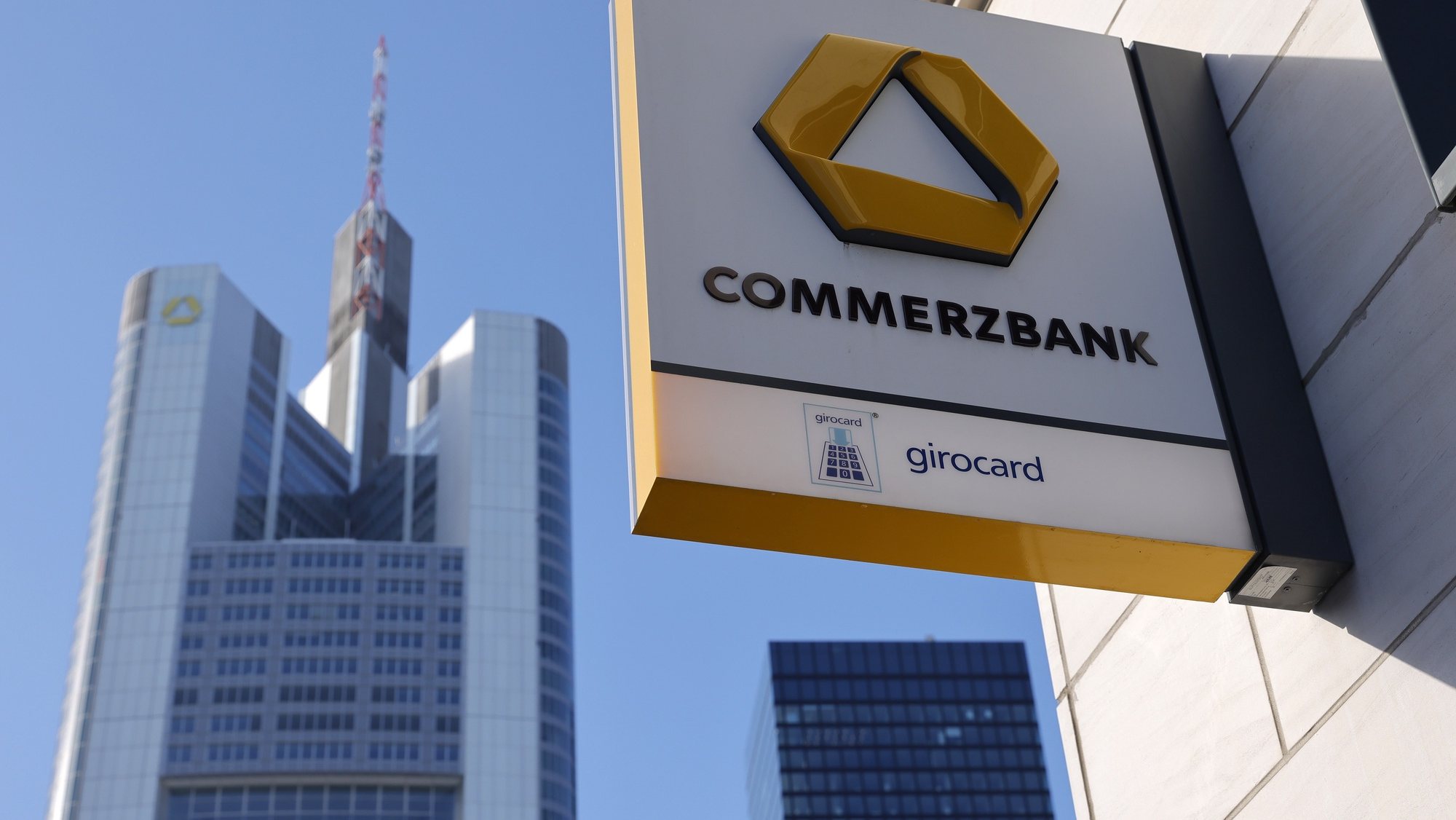 epa08998394 A view on the Commerzbank office tower seen behind a Commerzbank signage at its local branch in Frankfurt am Main, Germany, 09 February 2021. Commerzbank will release their preliminary business figures for the fourth quarter Q4 and the full year 2020 on 11 February 2021.  EPA/RONALD WITTEK