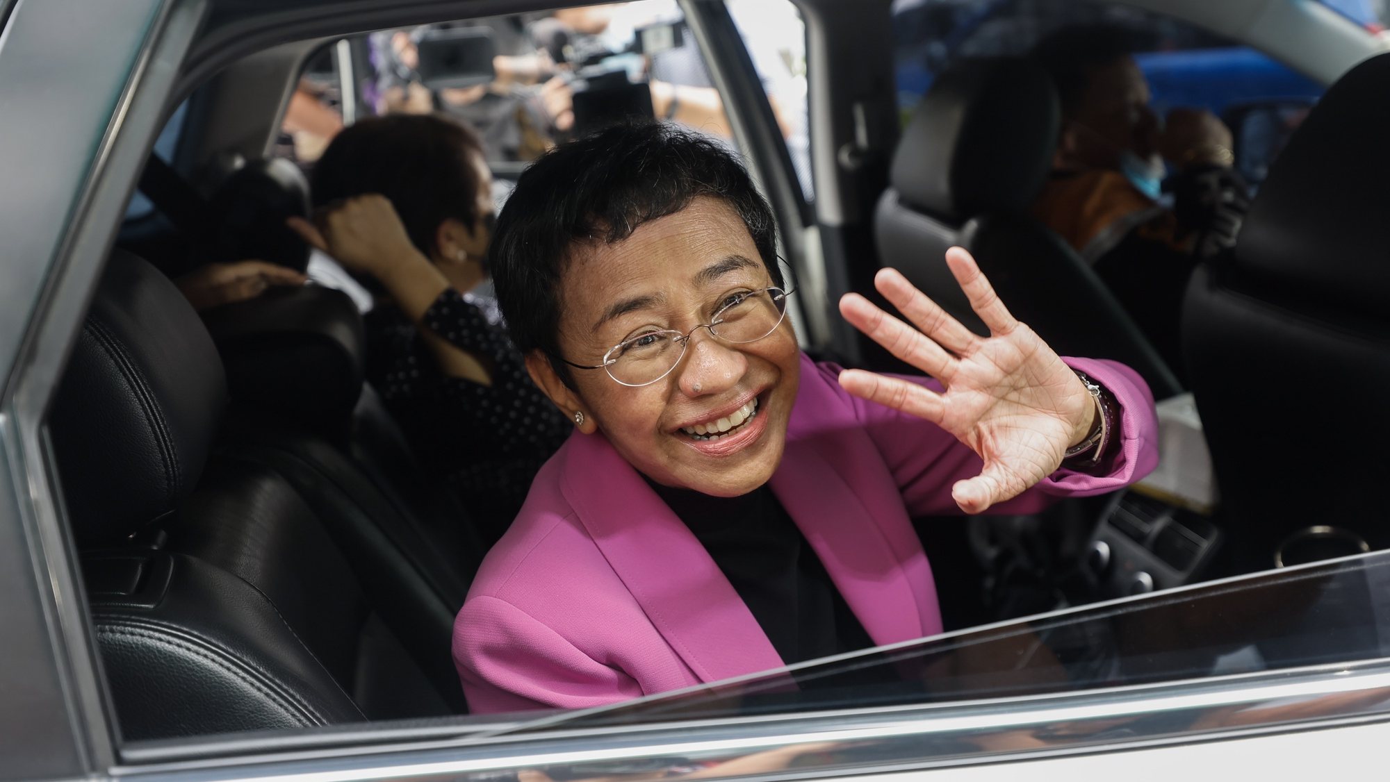 epa10412085 Nobel Peace Prize laureate Maria Ressa, the CEO of online news site Rappler, waves from a vehicle outside the Court of Tax Appeals in Quezon City, Metro Manila, Philippines, 18 January 2023. The tax court acquitted Ressa and Rappler Holdings Corporation of four tax evasion charges that were filed in 2018 during the term of former Philippine president Rodrigo Duterte.  EPA/ROLEX DELA PENA