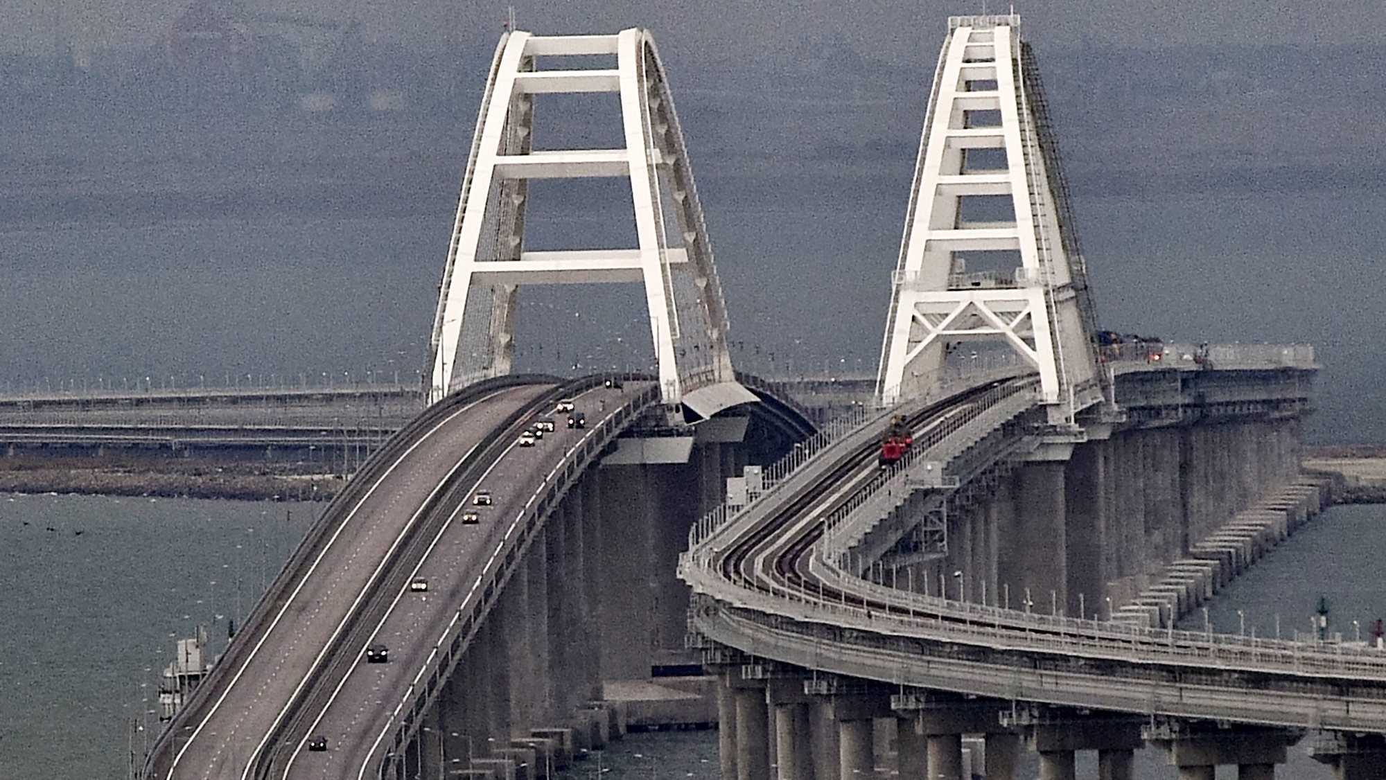epa10232212 Cars move on the Kerch Strait bridge in Crimea, 09 October 2022. Automobile traffic on the undamaged part of the Crimean bridge has been restored, the head of the annexed Crimea Sergey Aksyonov announced. The previous day, Russian authorities said that &quot;an explosion was set off at a cargo vehicle on the motorway part of the Crimean bridge on the side of the Taman peninsula, which set fire to seven fuel tanks of a train that was en route to the Crimean peninsula. Two motorway sections of the bridge partially collapsed.&quot;  EPA/STRINGER