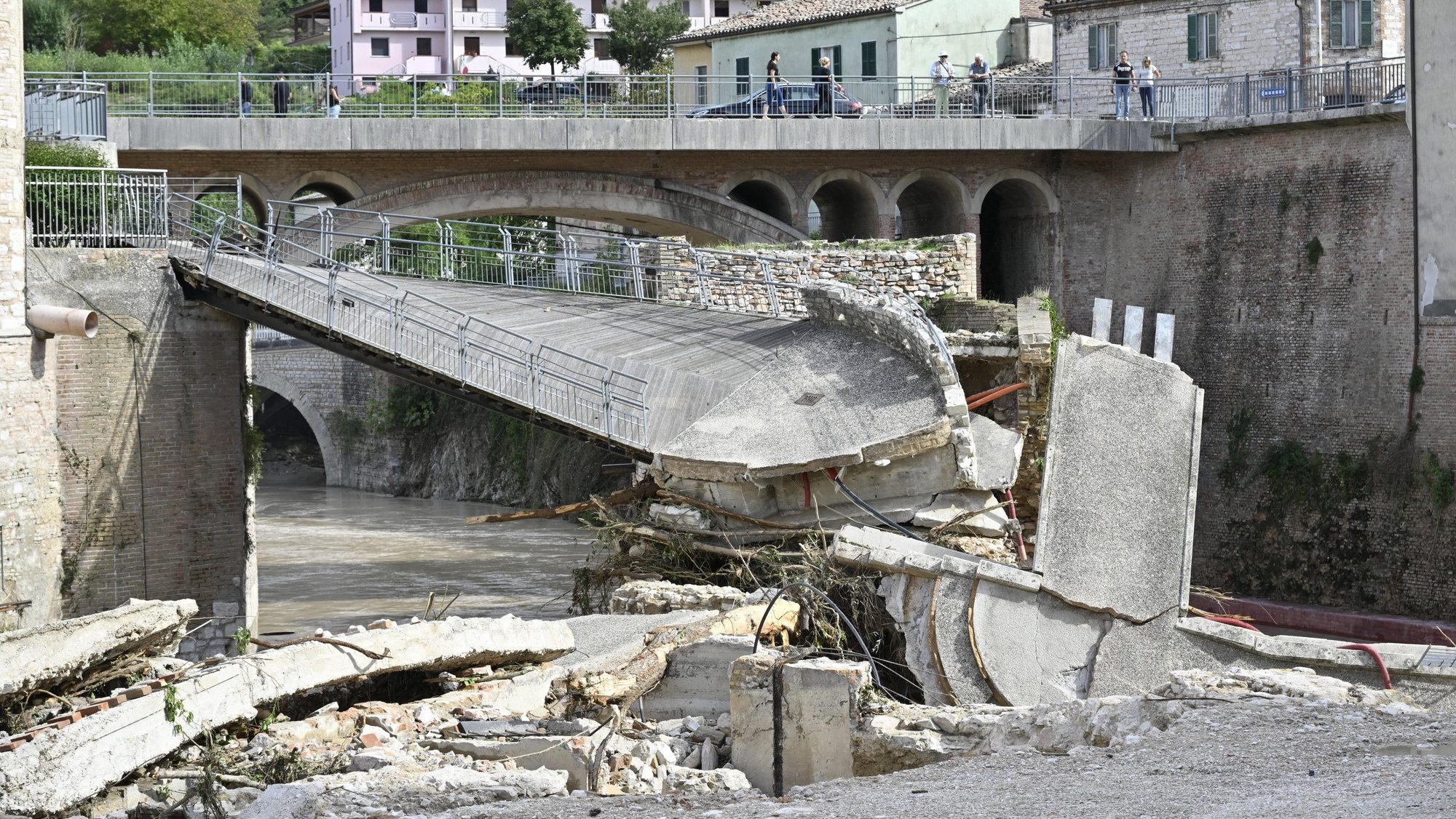 epa10188286 A collapsed pedestrian bridge in the aftermath of flash floods caused by the Sanguerone River due to an overnight rain bomb in Sassoferrato, Ancona province, central Italy, 16 September 2022. At least 10 people died following flash floods due to rain bombs and heavy winds in the province of Ancona.  EPA/ALESSANDRO DI MEO