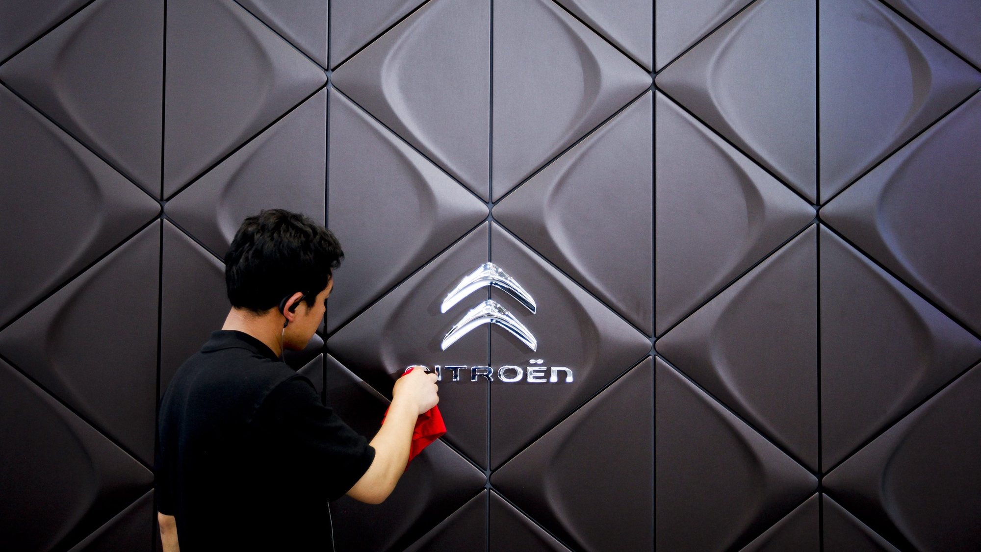 epa03194481 A man cleans the Citroen logo at the Auto China Show 2012 in Beijing, China, 24 April 2012. China&#039;s leading car show opened in Beijing on 23 April with automakers from around the world presenting more than a thousand car models. The automobile exhibition will run until 02 May. Annual sales growth dropped in 2011 to less than three percent after years of more than 20 percent increases. The total number of car sales in China for the year 2011 is reported in local media as 18.5 million with forecasts that the figure will reach 30 million by 2020.  EPA/DIEGO AZUBEL