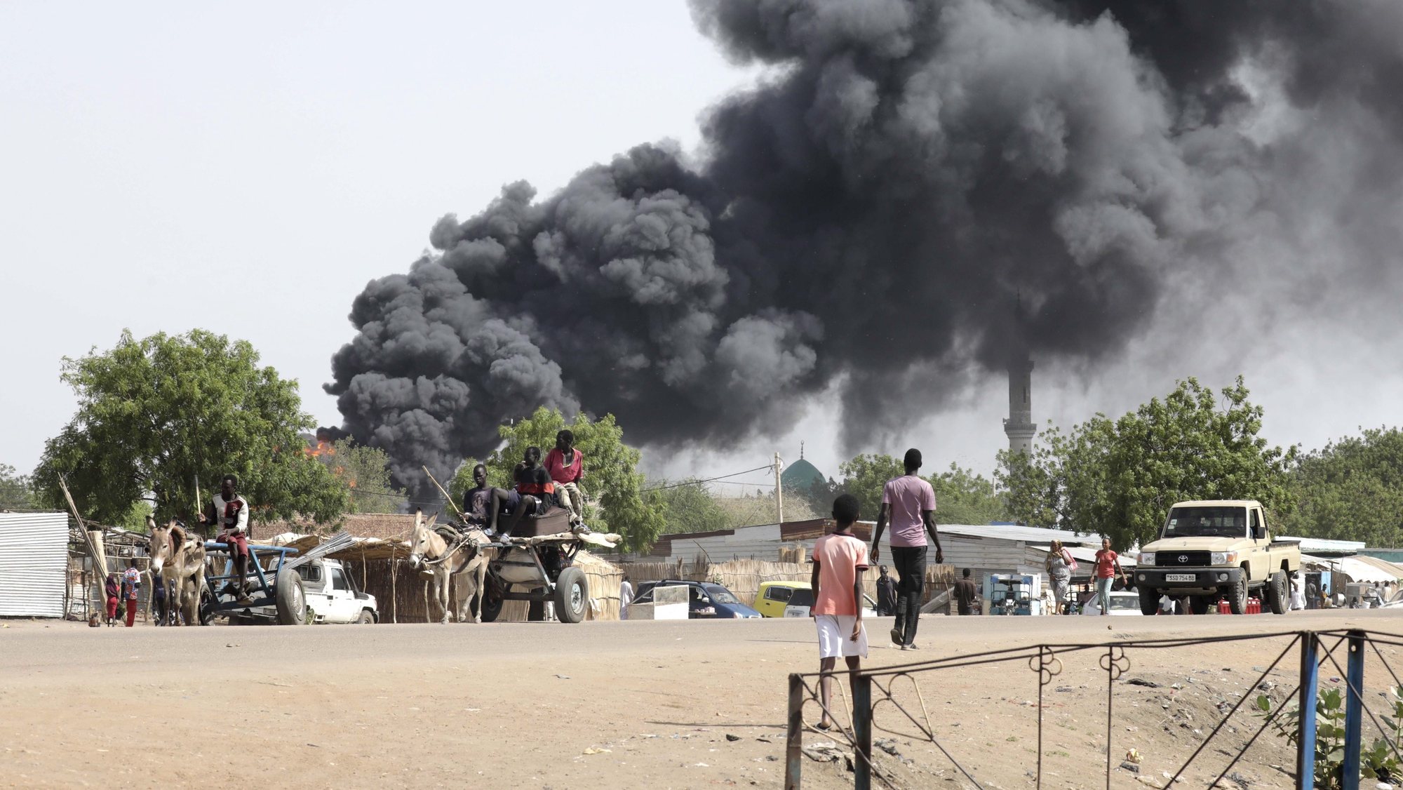 epa10625669 People drive as smoke rises from a fire at a market in the Upper Nile State town of Renk, South Sudan, 13 May 2023. According to UNHCR, at least 40,000 people have arrived into South Sudan since armed clashes between Sudan&#039;s military and rival paramilitary groups began in Khartoum and other parts of the country on 15 April 2023. Most of the refugees are part of the some 800,000 South Sudanese who had previously fled the war in South Sudan and who are now returning to a country with tensions still remaining in many areas, and more than two million internally displaced people. Upon arriving at the Joda border crossing, the refugees head to a transit area set up by UNHCR in the small town of Renk, where various UN agencies assist them with registration, food, health check and logistics.  EPA/AMEL PAIN