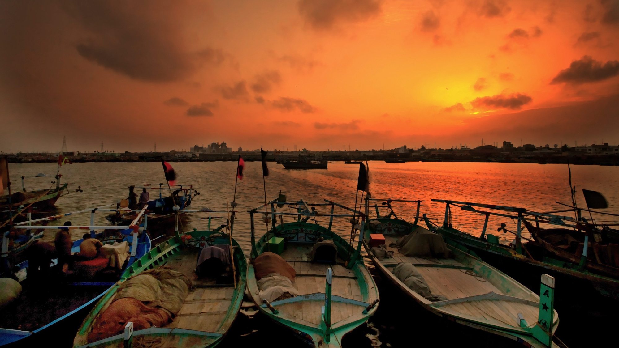 epa04201783 Fishermen fasten their boats as the sun sets in Karachi, Pakistan, 11 May 2014.  EPA/OMER SALEEM