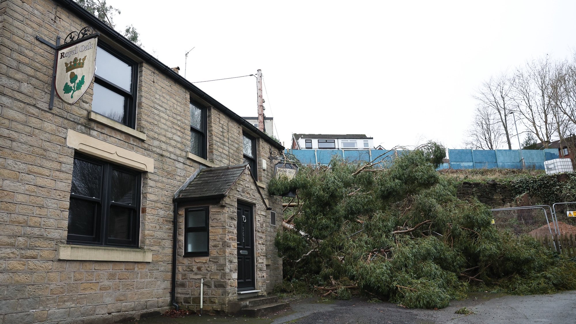 epa11046701 A fallen tree against the side of the Royal Oak pub in Tameside, Britain, 28 December 2023. A major incident has been declared after the Tameside area of Greater Manchester was hit by a localized tornado on the evening of 27 December 2023.  EPA/ADAM VAUGHAN