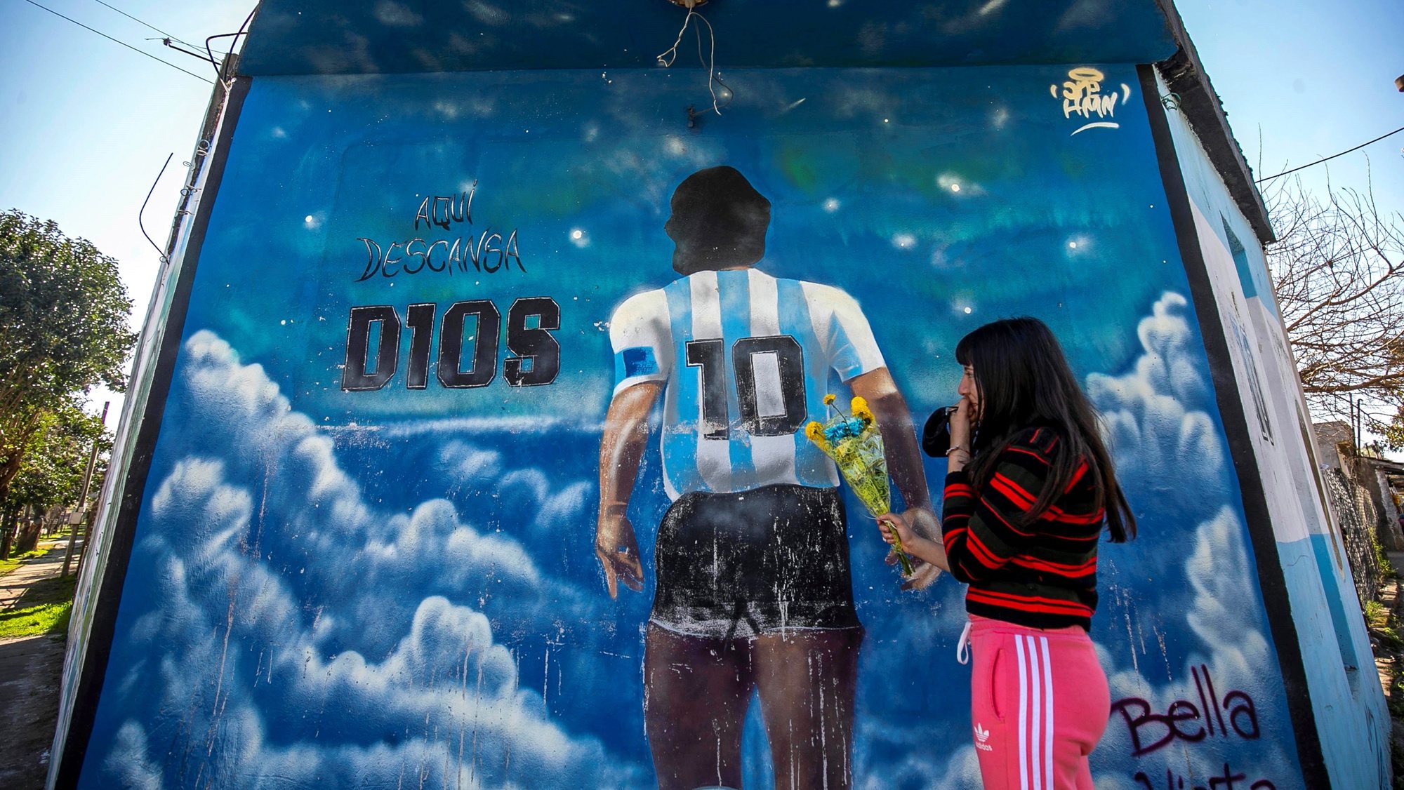 epa09359843 A view of a mural dedicated to late Diego A. Maradona in Lomas de Marilo neighborhood in the town of Bella Vista, Buenos Aires province, Argentina, 21 July 2021 (issued 23 July 2021). A few less than eight months after the death of Diego Maradona, residents of the neighborhood where he was buried told Efe that the area experiences a great &#039;revolution&#039;, both artistic and commercial, and that, still deceased, the soccer star continues to give them joy.  EPA/Demian Alday Estevez ACOMPAÃ‘A CRÃ“NICA***